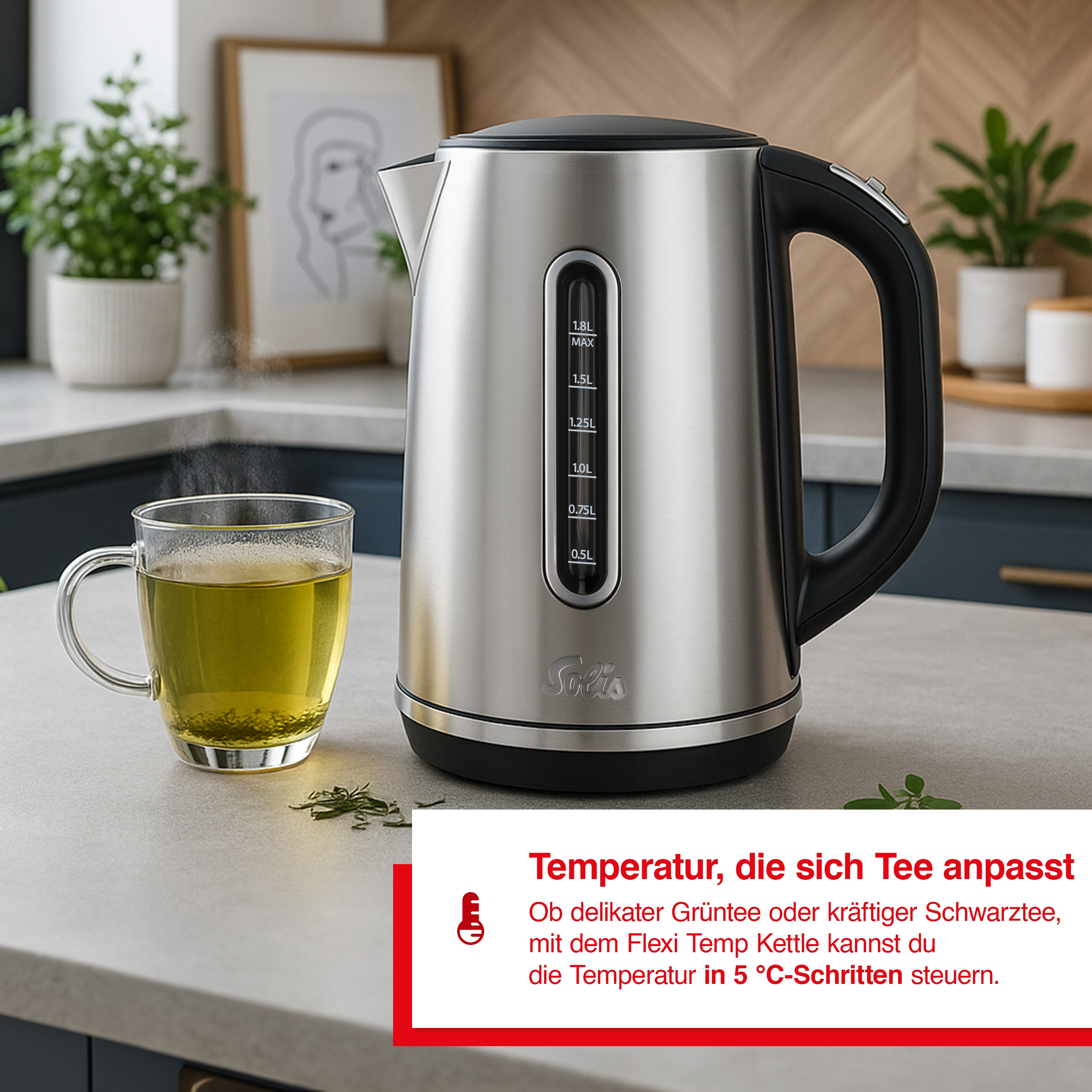 Een roestvrijstalen waterkoker en een glas thee op een aanrecht. De achtergrond toont planten en een houten muur.