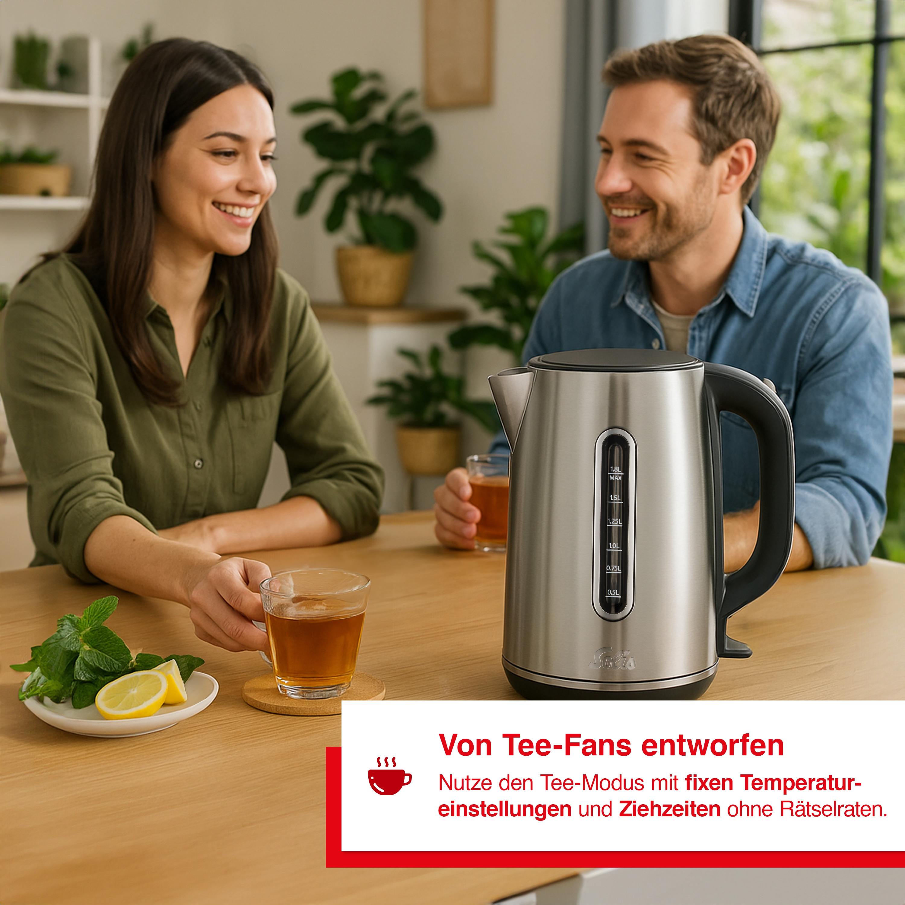 Een lachend stel geniet van thee met een waterkoker op tafel. Munt en citroen op een bord.