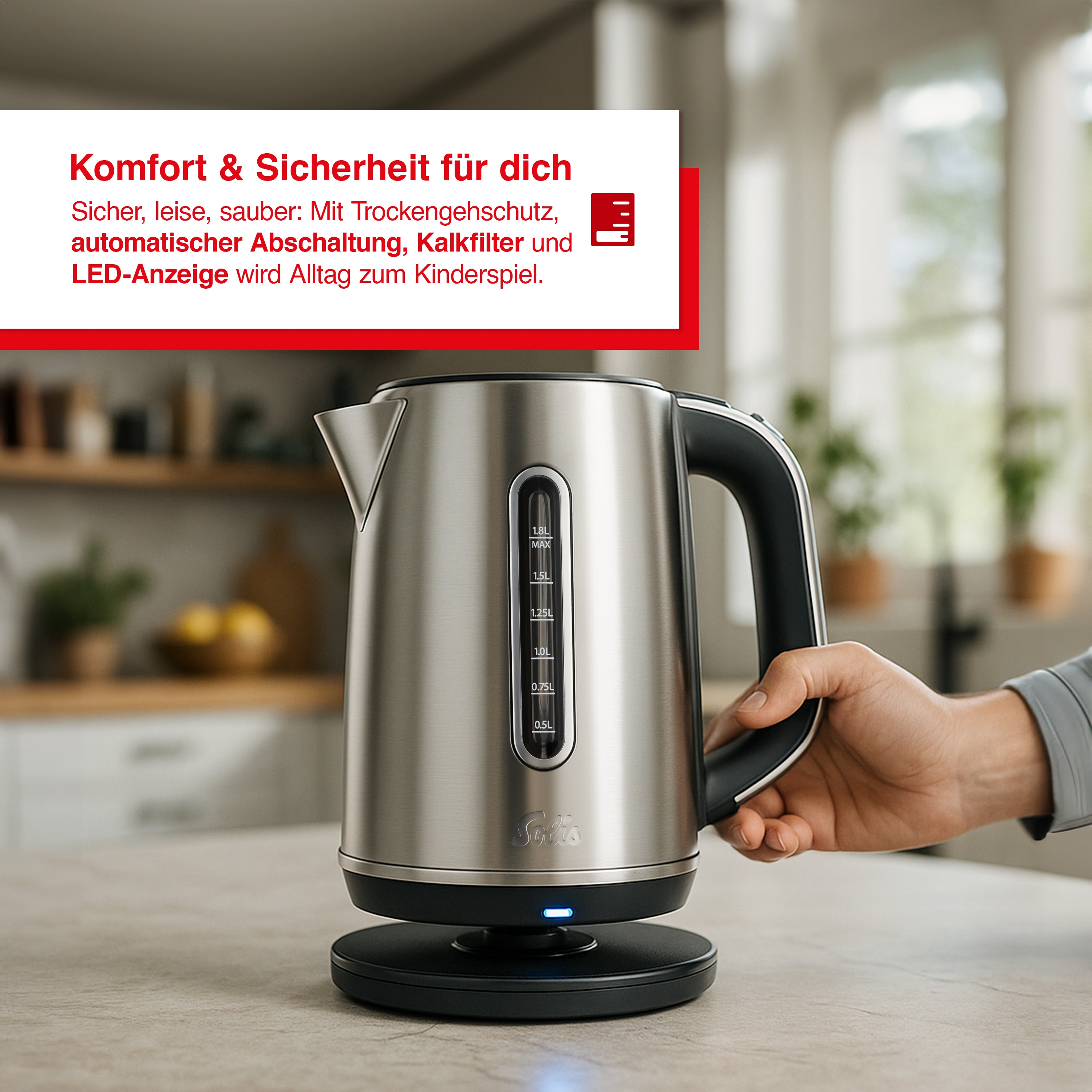 Een roestvrijstalen elektrische waterkoker met een zwarte handgreep wordt door een hand vastgehouden. De waterkoker staat op een zwarte voet.