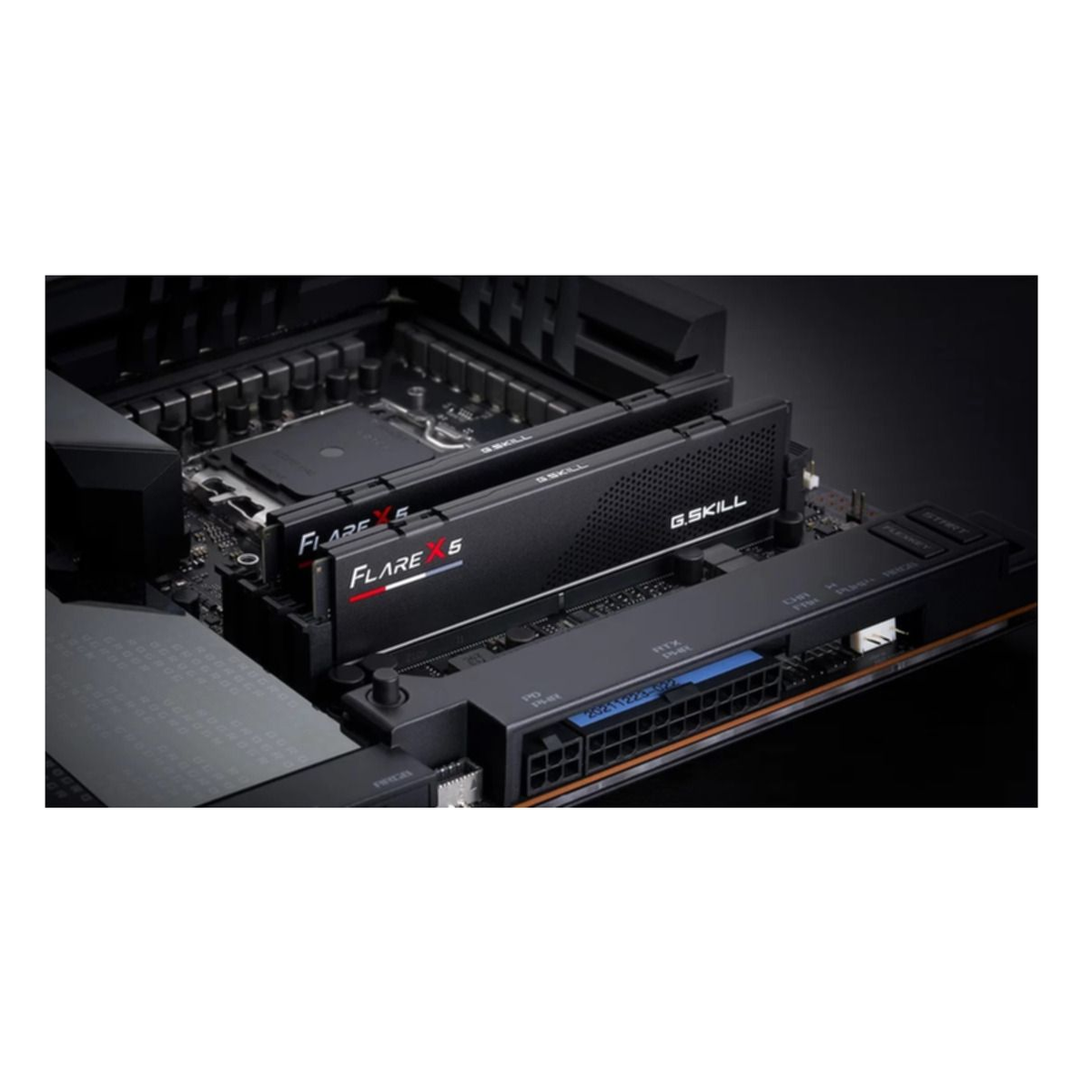 Czarne kości RAM G.SKILL Flare X5 zainstalowane w płycie głównej. Kości mają czerwony i biały tekst. Tło jest ciemne.