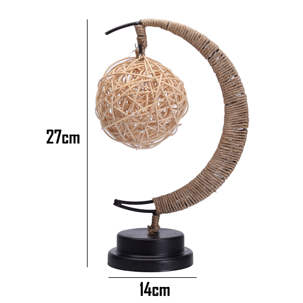 Eine dekorative Lampe mit einem Lampenschirm aus gewebtem Ball, der von einem gebogenen, seilumwickelten Rahmen auf einem schwarzen Sockel getragen wird.