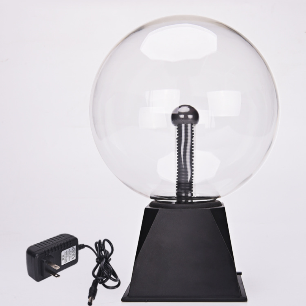 Eine Plasma-Kugellampe mit schwarzem Sockel und zentraler Elektrode. Ein schwarzes Netzteil ist mit einem schwarzen Kabel an der Lampe angeschlossen.