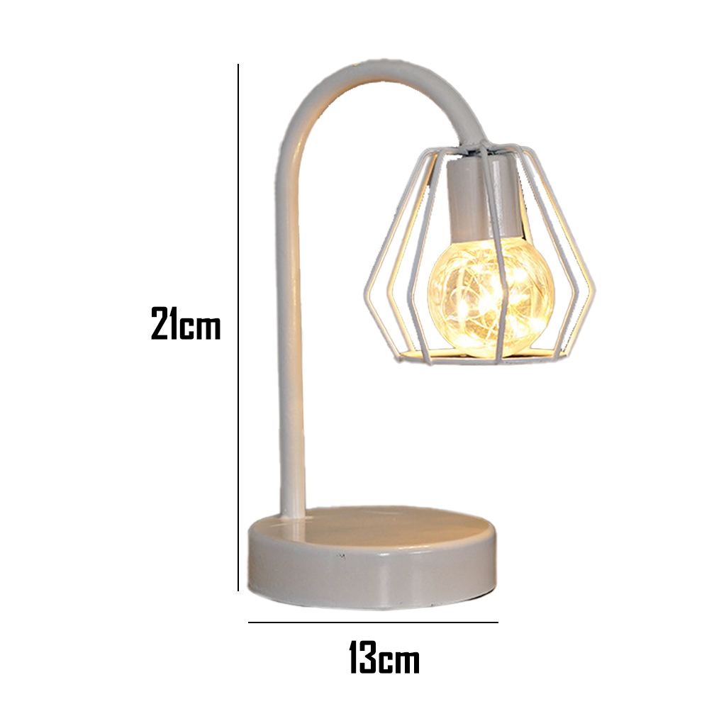 Eine weiße Schreibtischlampe mit geometrischem Schirm, leuchtender Glühbirne und rundem Sockel. Maße: 21 cm hoch, 13 cm breit.