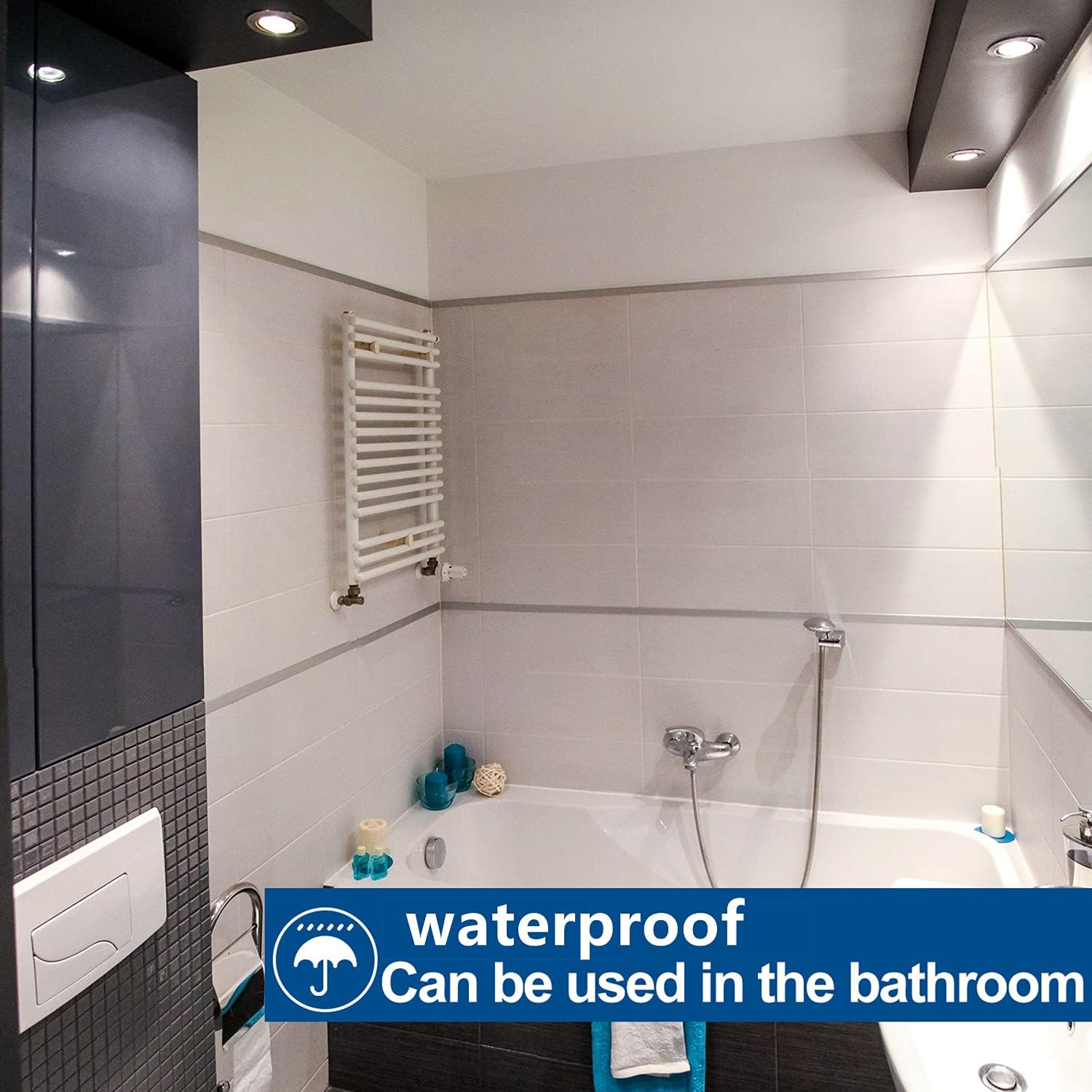Badezimmer mit weißer Badewanne, Fliesen, Handtuchhalter und einem blauen wasserdichten Schild. Der Raum ist modern und sauber.