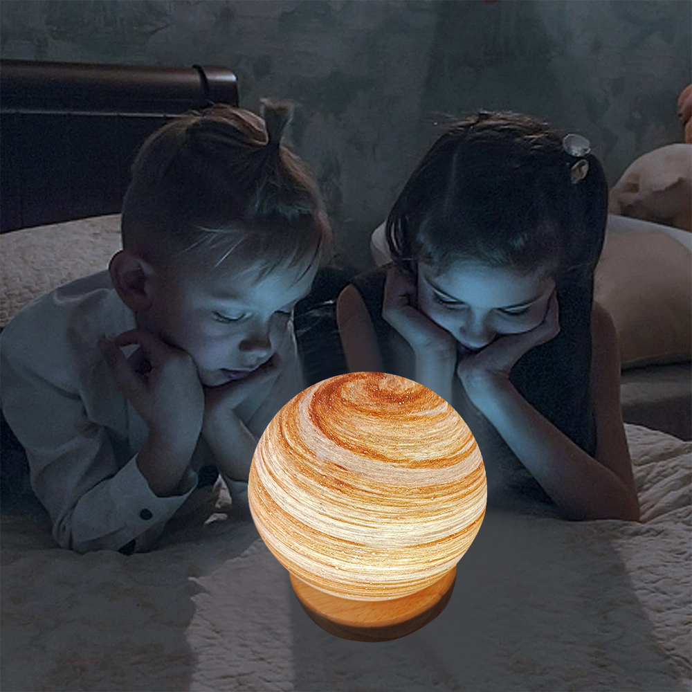 Zwei Kinder betrachten einen beleuchteten Globus auf einem Bett. Der Globus hat einen Holzsockel. Der Raum ist schwach beleuchtet.