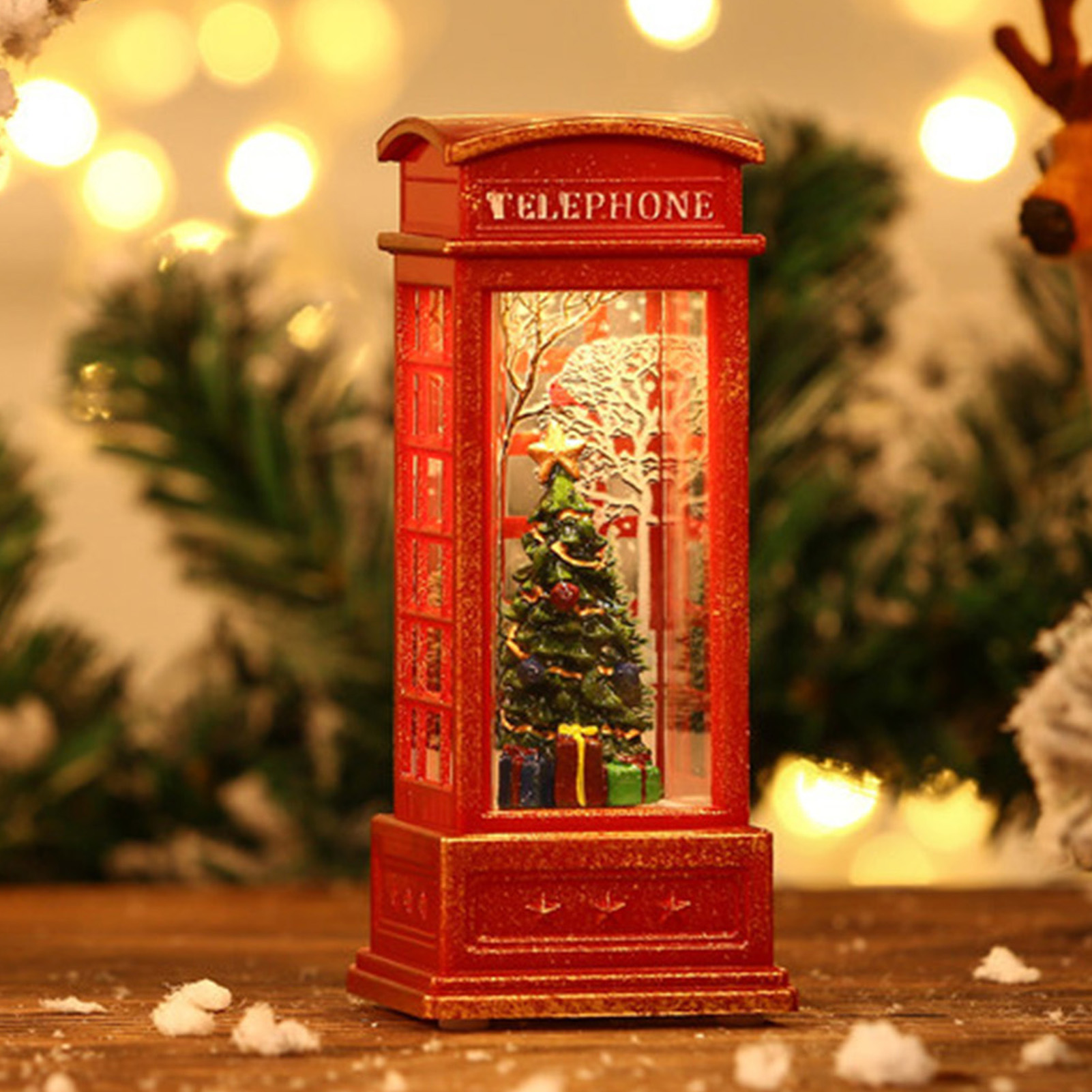 Eine rote Telefonzelle mit einem Weihnachtsbaum im Inneren, umgeben von verschwommenen Lichtern und Grün.