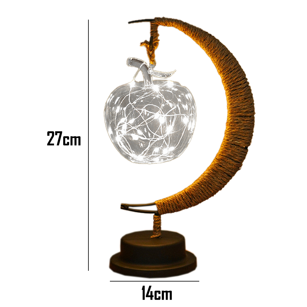 Eine dekorative Lampe mit apfelförmigem Glas gefüllt mit Lichtern, getragen von einem braunen, gebogenen Rahmen auf dunkler Basis.
