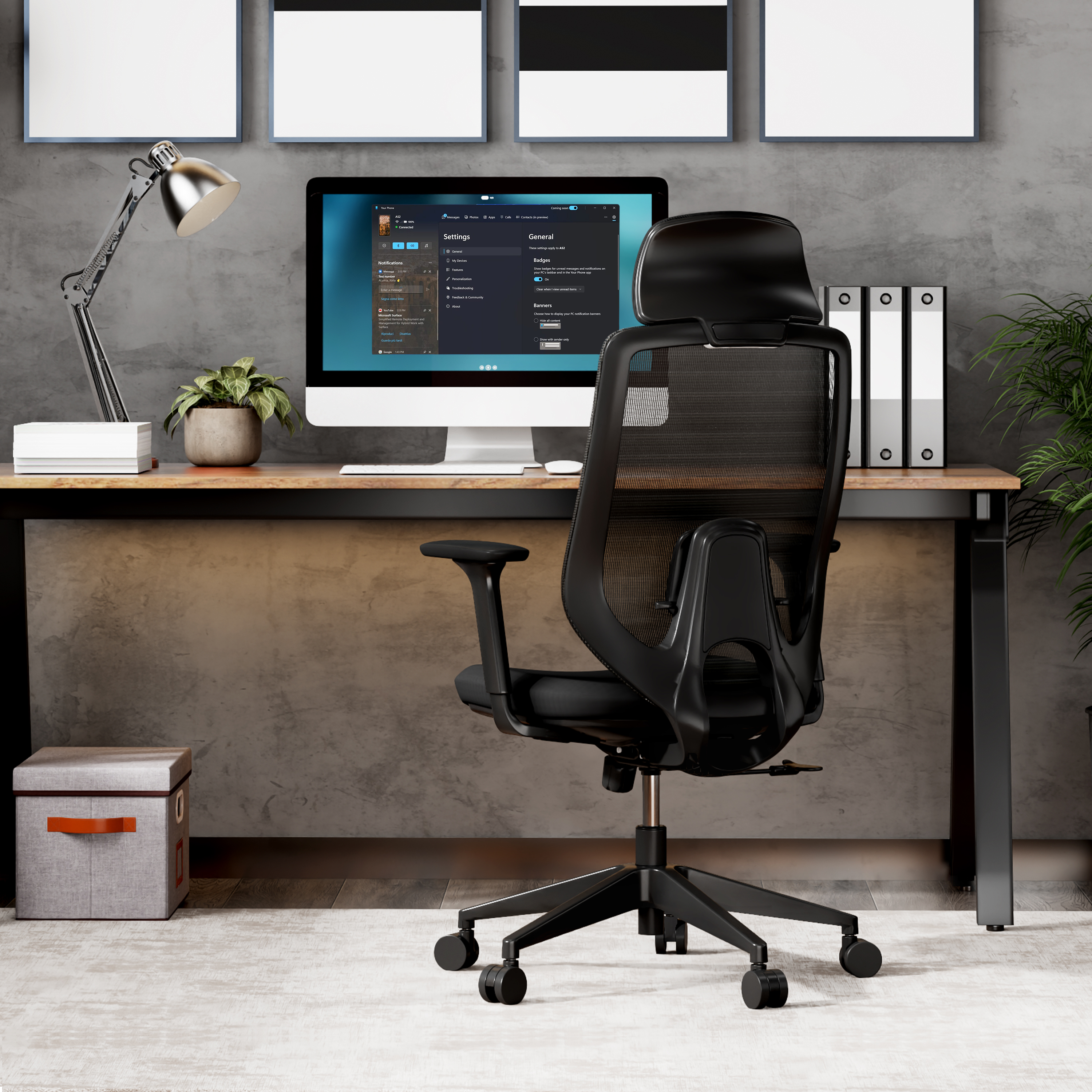 Büroausstattung mit Computer, schwarzem Stuhl, Schreibtisch, Pflanze und Kunst an der Wand. Grau strukturierte Wand.