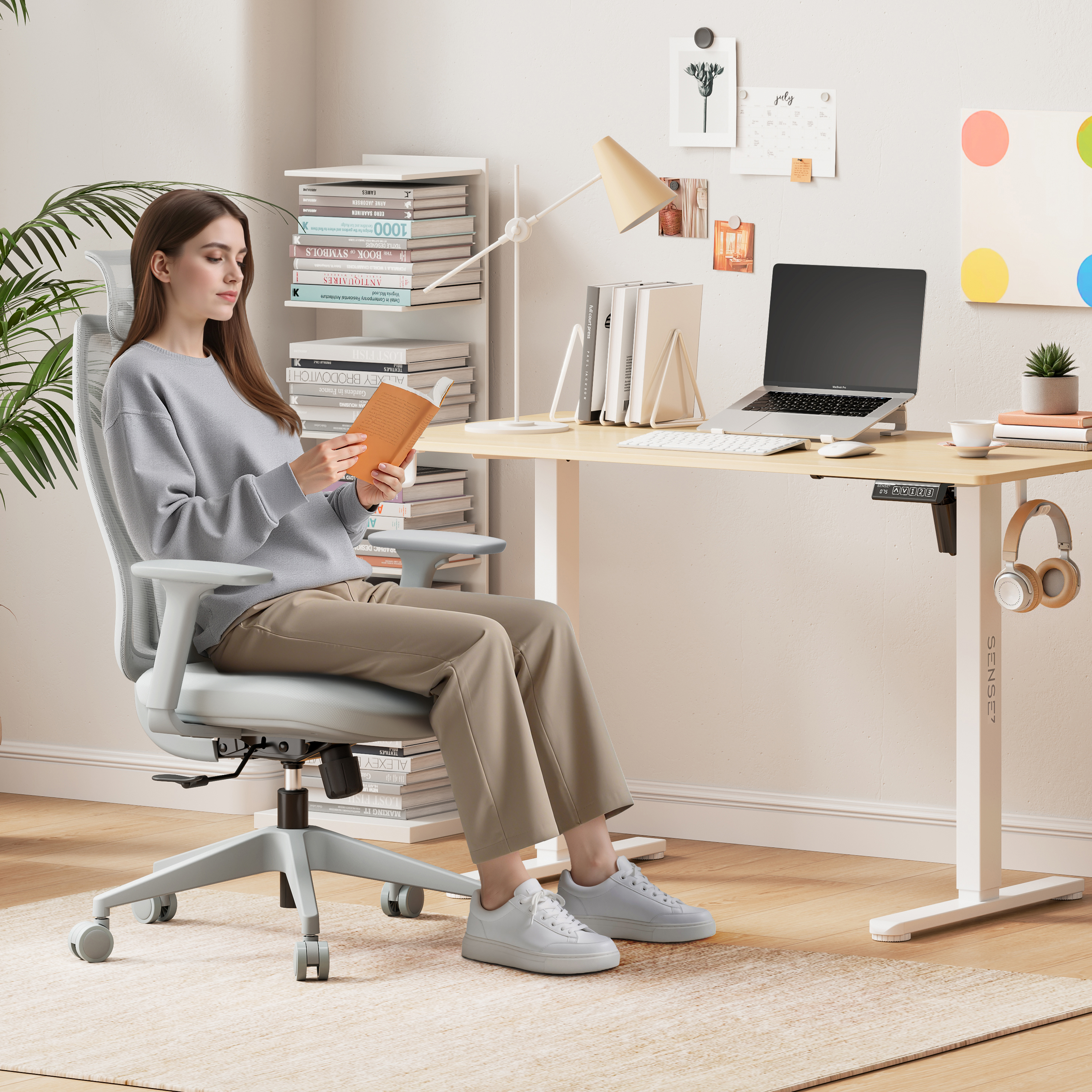 Una donna legge un libro in un ufficio domestico. Sono visibili anche un laptop, libri, una lampada da scrivania e cuffie.