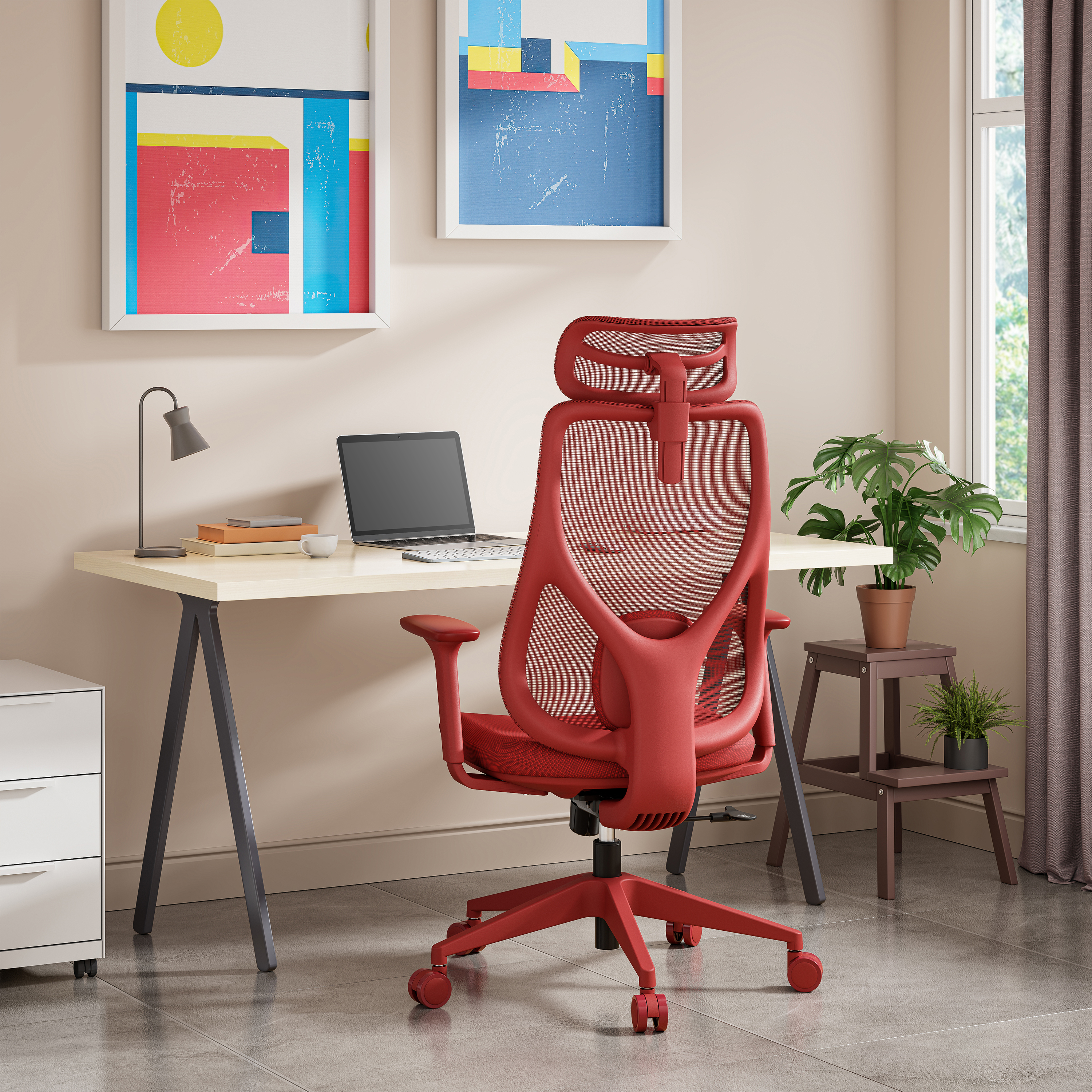 Ein roter Bürostuhl steht vor einem Schreibtisch. Ein Laptop, eine Lampe und Kunstwerke sind im Hintergrund sichtbar.
