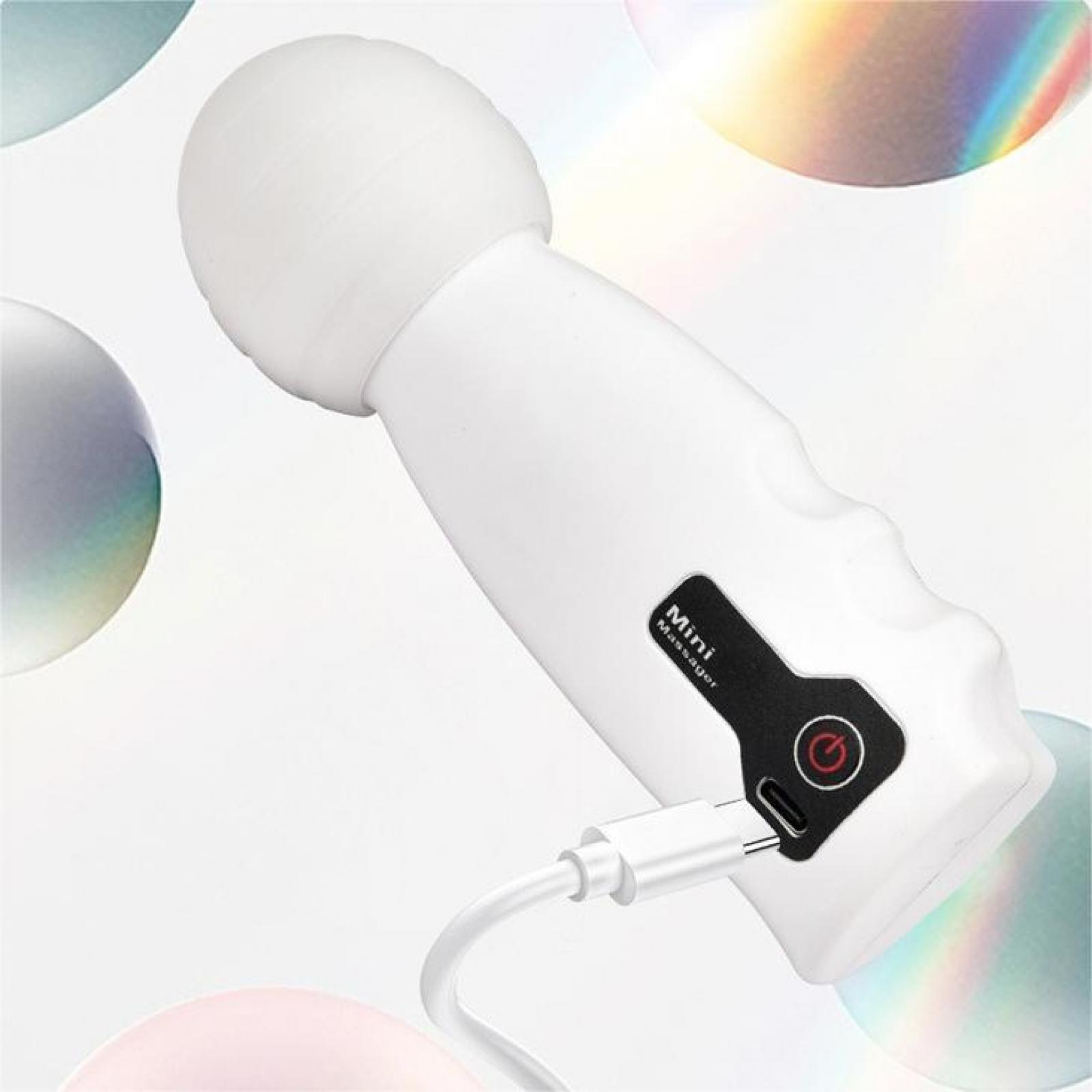 Weißes Mini-Massagegerät mit rundem Kopf, Ladeanschluss und Ein-/Aus-Taste. Ein Ladekabel ist eingesteckt.