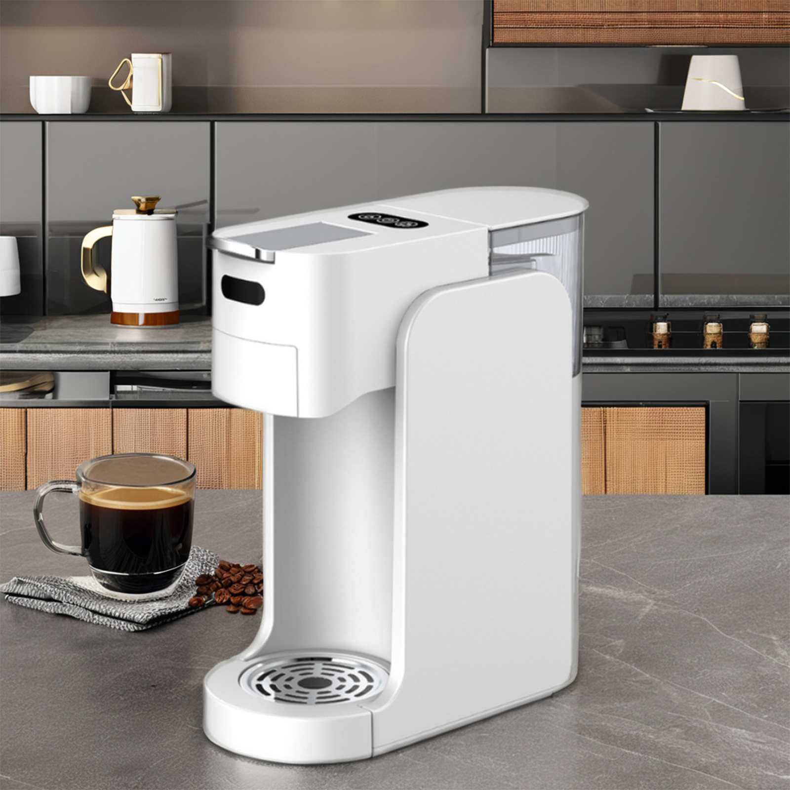 Eine weiße Kaffeemaschine auf einer Arbeitsplatte, mit einer Tasse Kaffee und Kaffeebohnen. Im Hintergrund Küchenschränke.