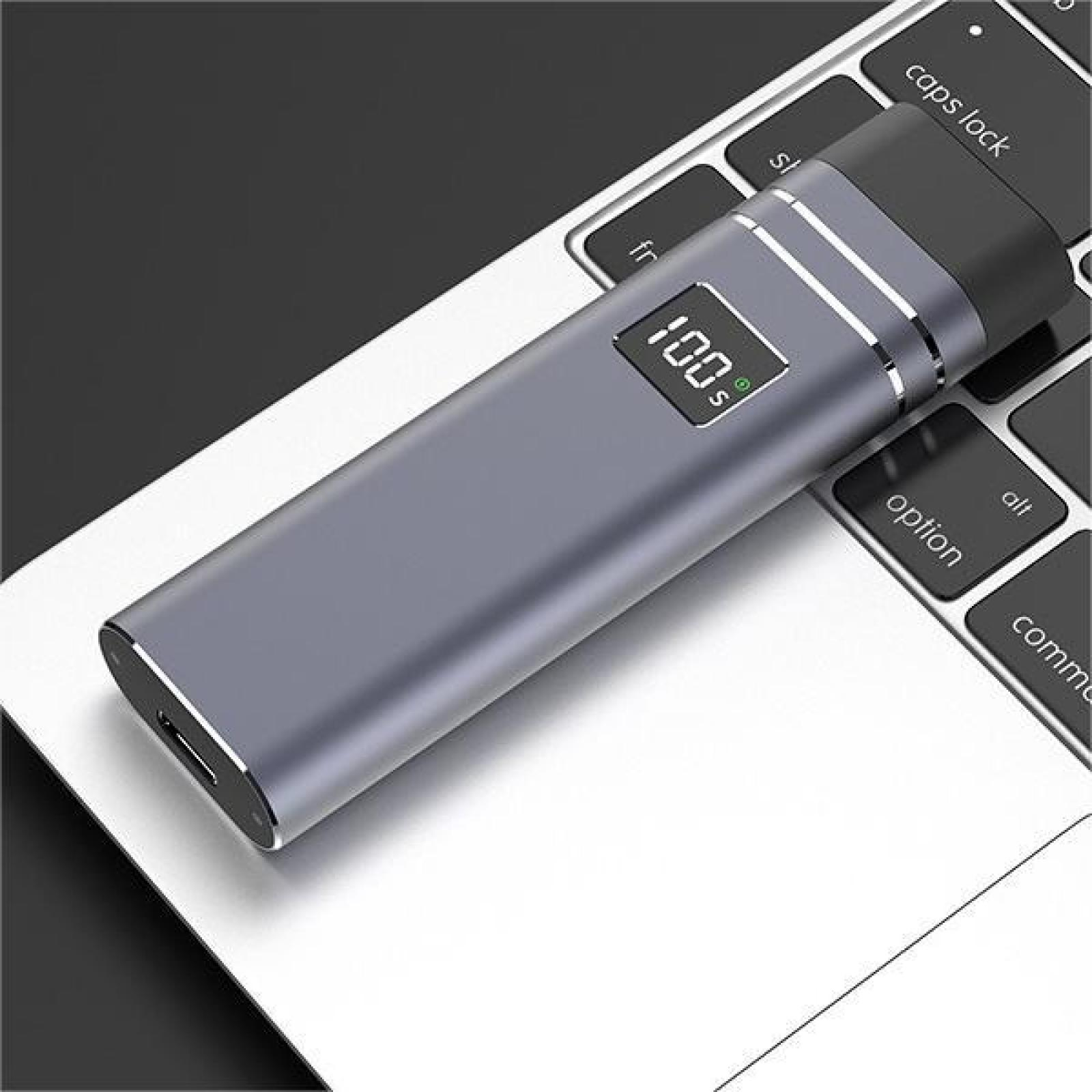 Ein graues Gerät mit Anzeige von 100% liegt auf einer Laptop-Tastatur. Das Gerät befindet sich neben der Taste 'caps lock'.