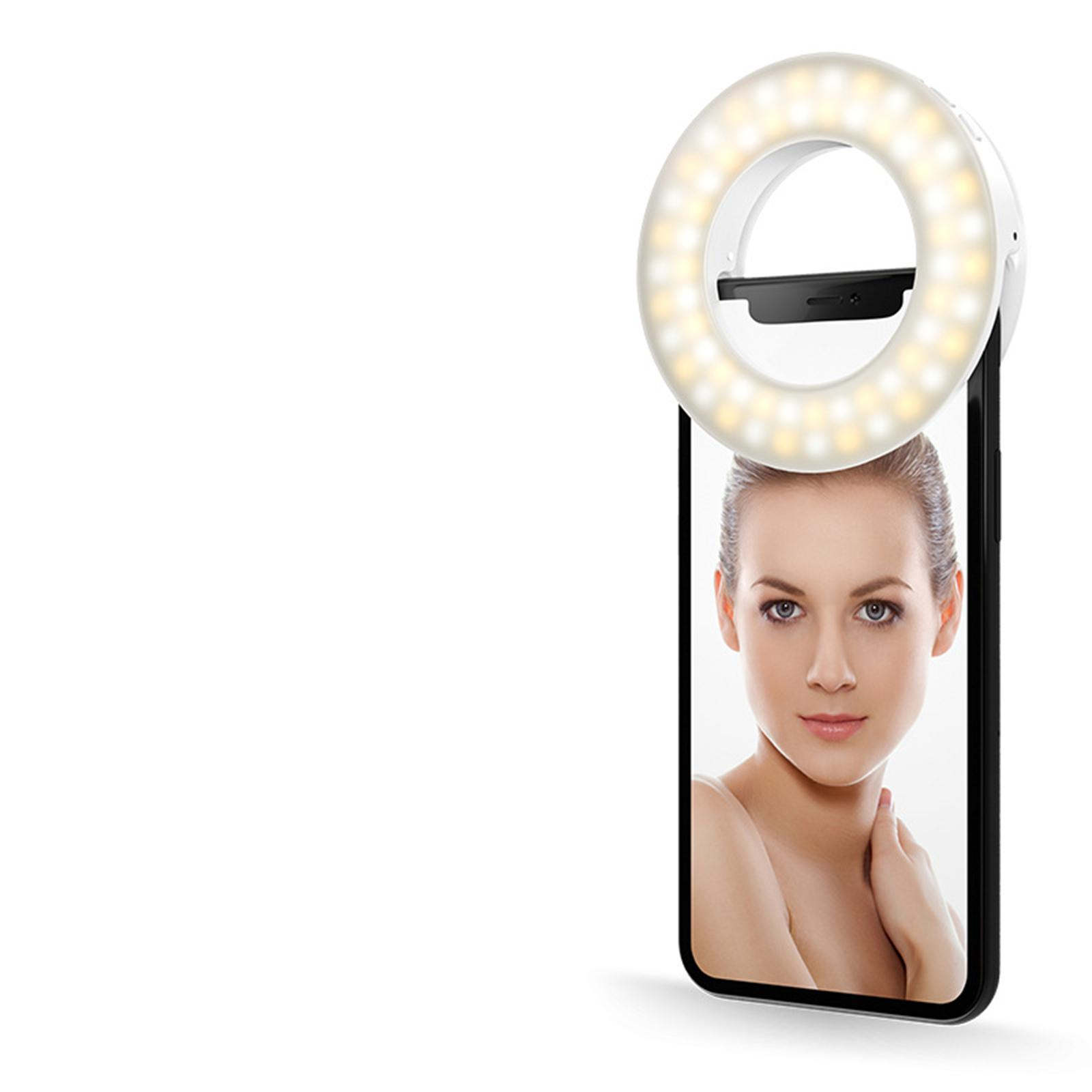 Das Gesicht einer Frau spiegelt sich auf einem Smartphone mit Ringlicht.