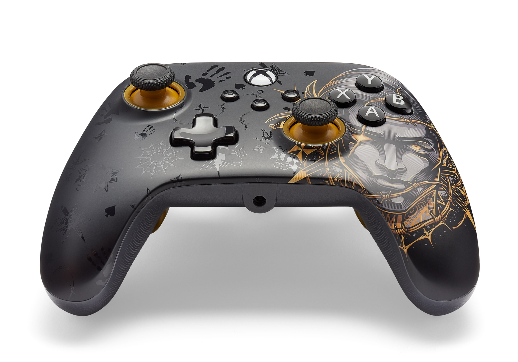 Czarny kontroler Xbox z grafiką. Zawiera wzór twarzy, odciski dłoni i piki. Złote akcenty na joystickach i przyciskach.