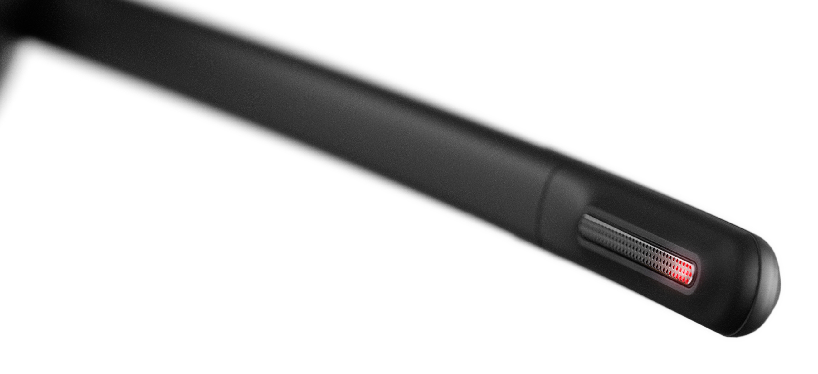 Close-up of a black device's edge. It features a speaker grill with a red light and a smooth, rounded body, on white background.