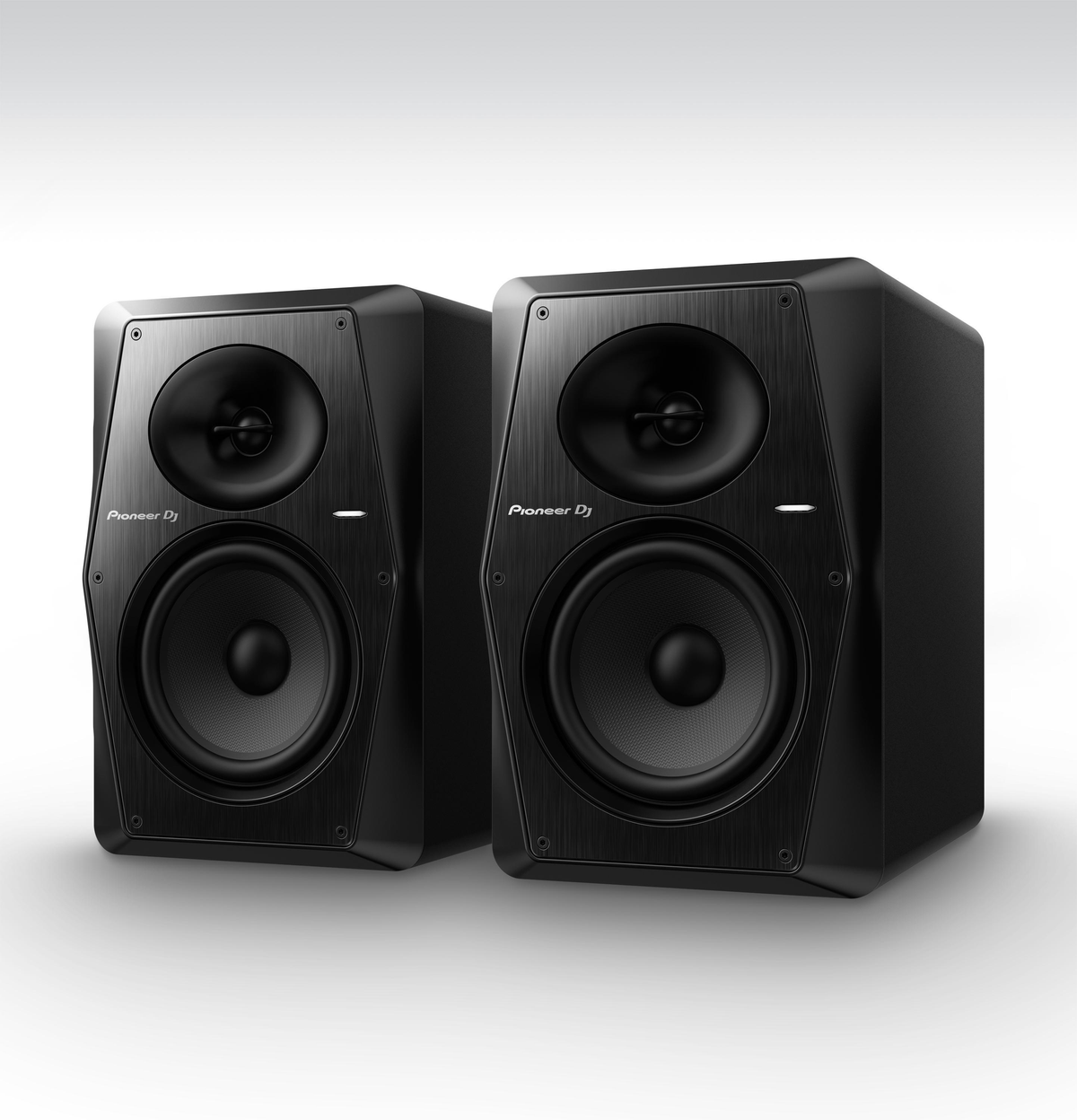 Dos altavoces Pioneer DJ negros. Cada uno tiene un woofer y un tweeter. Los altavoces están sobre una superficie blanca.