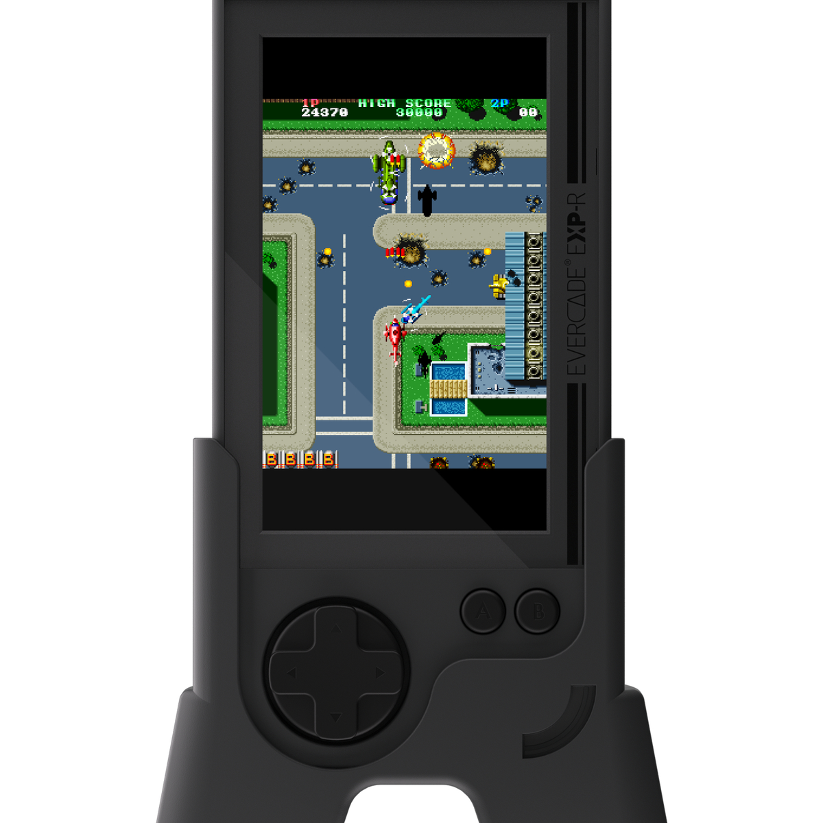 Un dispositivo retro portátil muestra un juego de disparos de arriba hacia abajo. Aviones verdes y rojos combaten sobre un mapa de la ciudad.