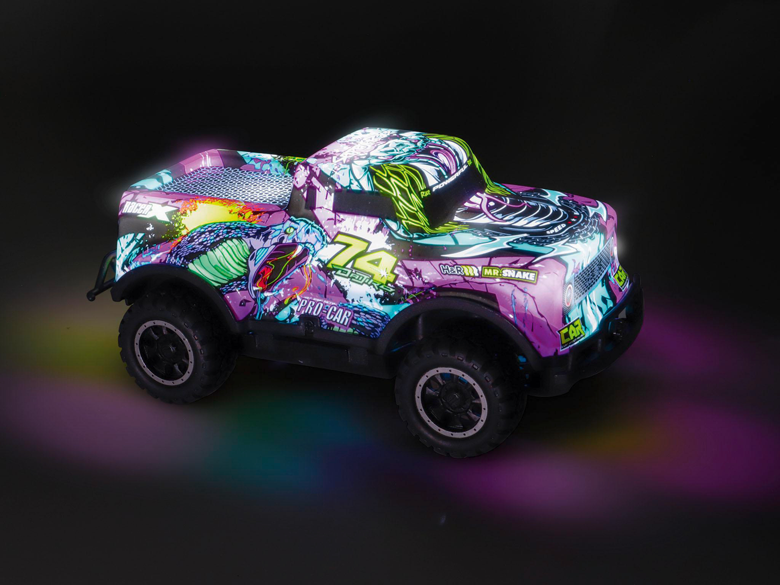 Un coche de juguete colorido con gráficos de serpiente y el número 74. Tiene ruedas grandes y está iluminado con luces de neón sobre fondo negro.