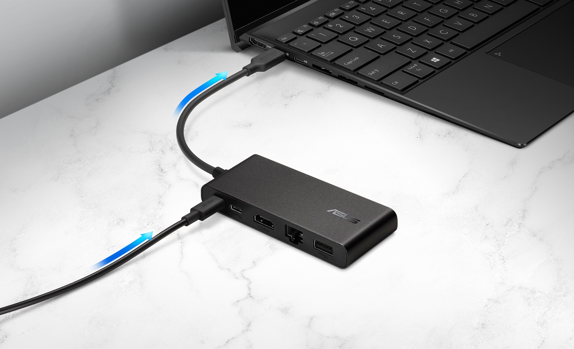 A black laptop connected to a black ASUS hub with cables. Blue arrows indicate data flow. The surface is white with marble effect.
