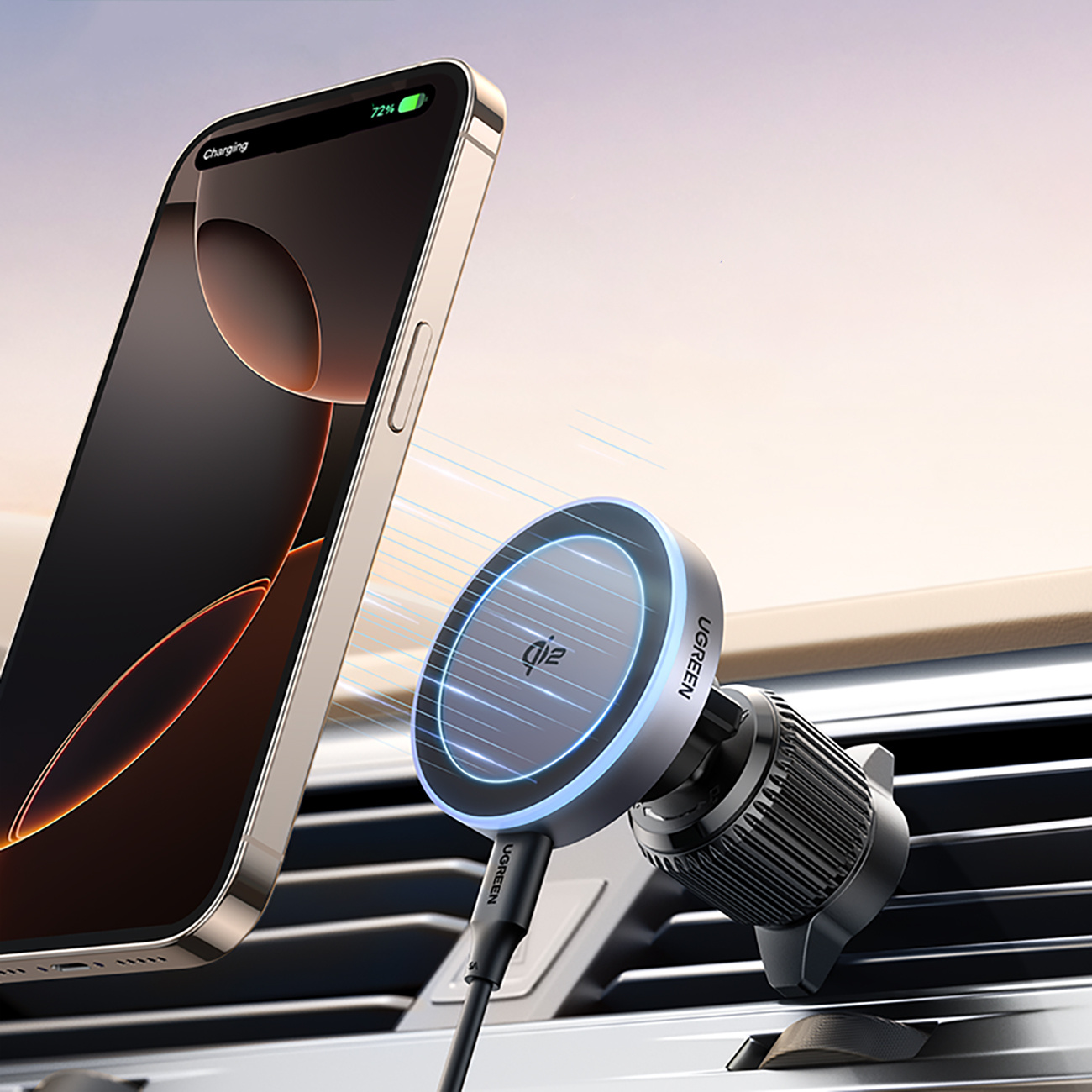 Telefon ładuje się na uchwycie wentylacyjnym w samochodzie. Telefon jest czarny i złoty. Uchwyt jest srebrny i czarny, z niebieskim światłem.
