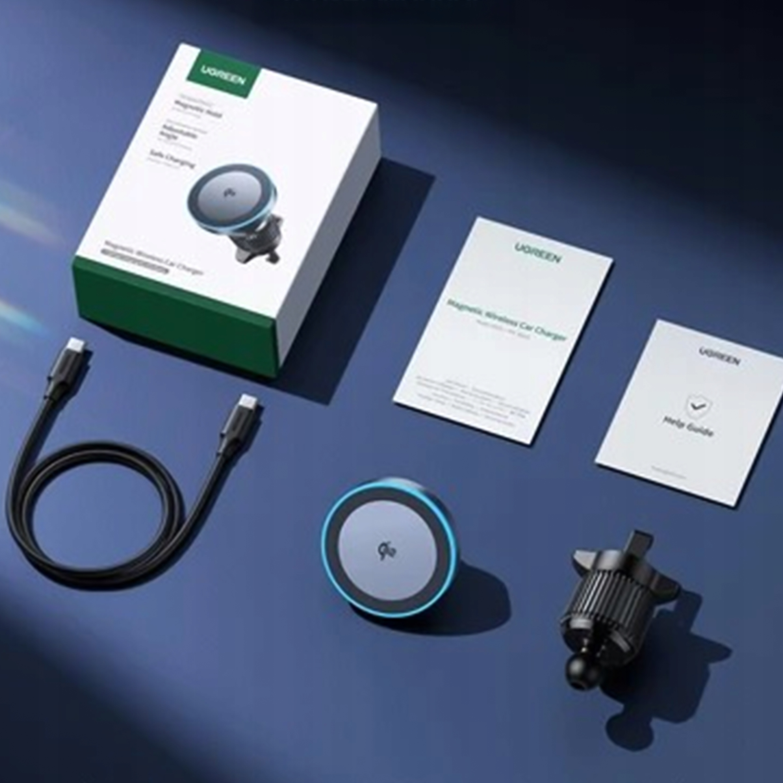 Ujęcie produktu. Zestaw magnetycznej ładowarki samochodowej UGREEN z pudełkiem, ładowarką, instrukcją i kablem na niebieskiej powierzchni.