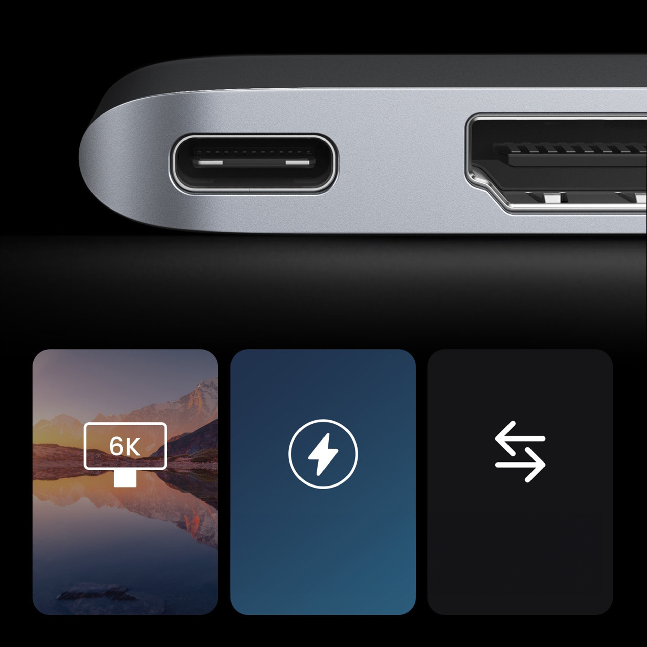 Zbliżenie srebrnego urządzenia z portem USB-C i czytnikiem kart. Poniżej trzy ikony: wyświetlacz, ładowanie i transfer danych.