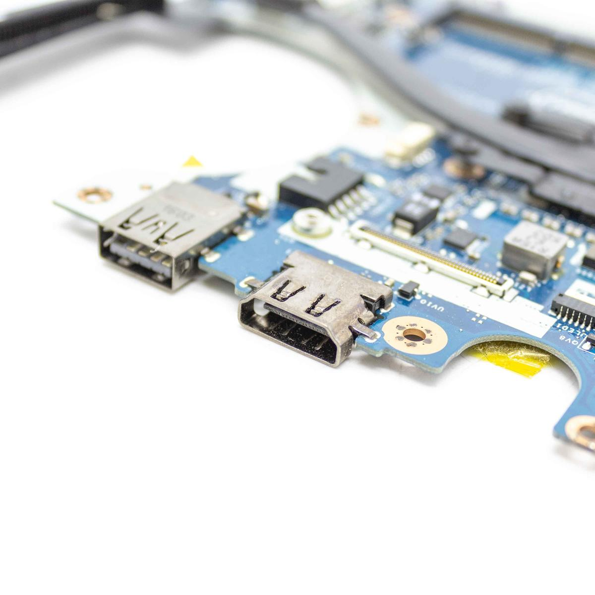 Primo piano di un circuito stampato blu con porte USB e componenti elettronici. Sfondo bianco. Messa a fuoco sulle porte.
