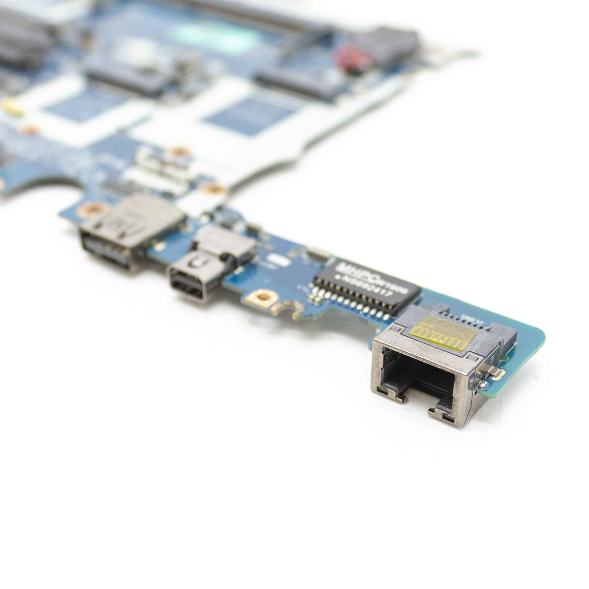 Una scheda di circuito blu con varie porte e chip. Una porta di rete è visibile a destra.
