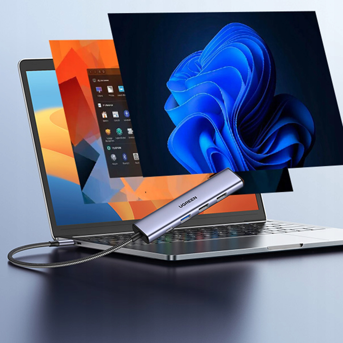 Laptop z podłączonym hubem UGREEN. Ekrany Windows w tle. Laptop znajduje się na jasnej powierzchni.