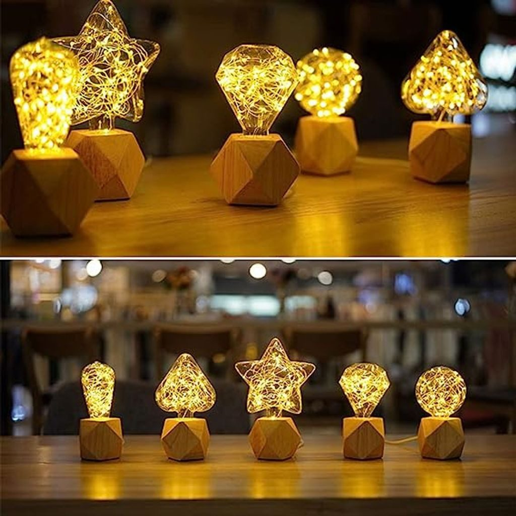 Podświetlane lampy dekoracyjne w różnych kształtach, w tym gwiazda, diament i kula, na drewnianych podstawach. Tło przedstawia rozmyte wnętrze.