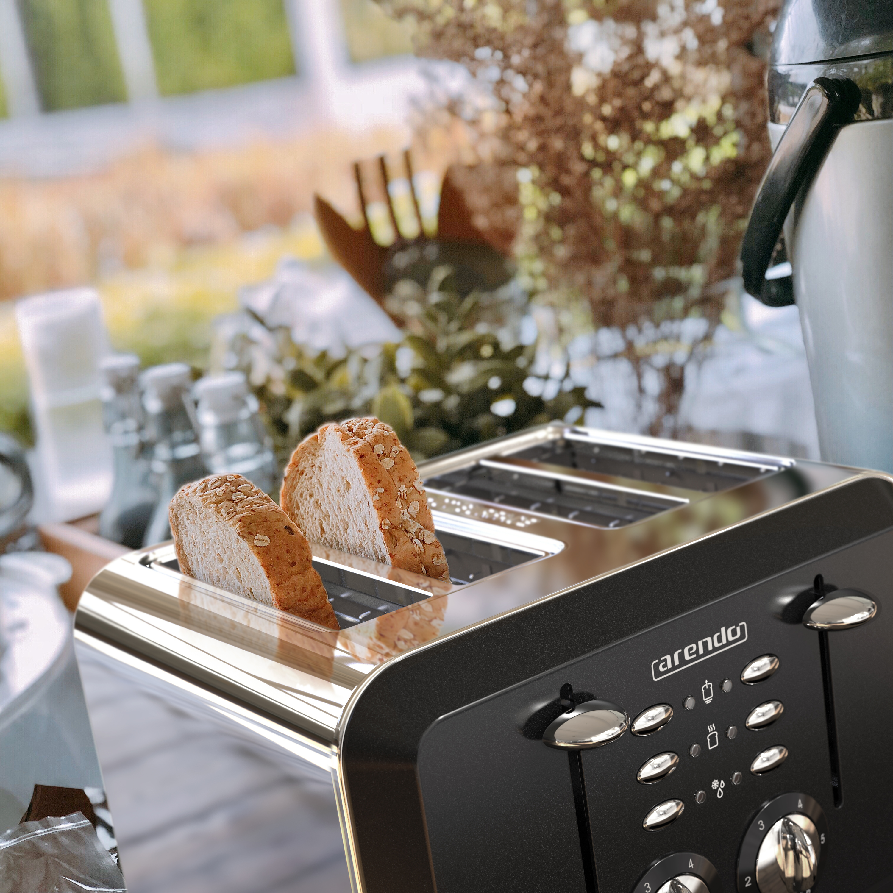 Ein Toaster mit zwei Brotscheiben, vor einem verschwommenen Hintergrund mit Pflanzen und anderen Küchenartikeln.