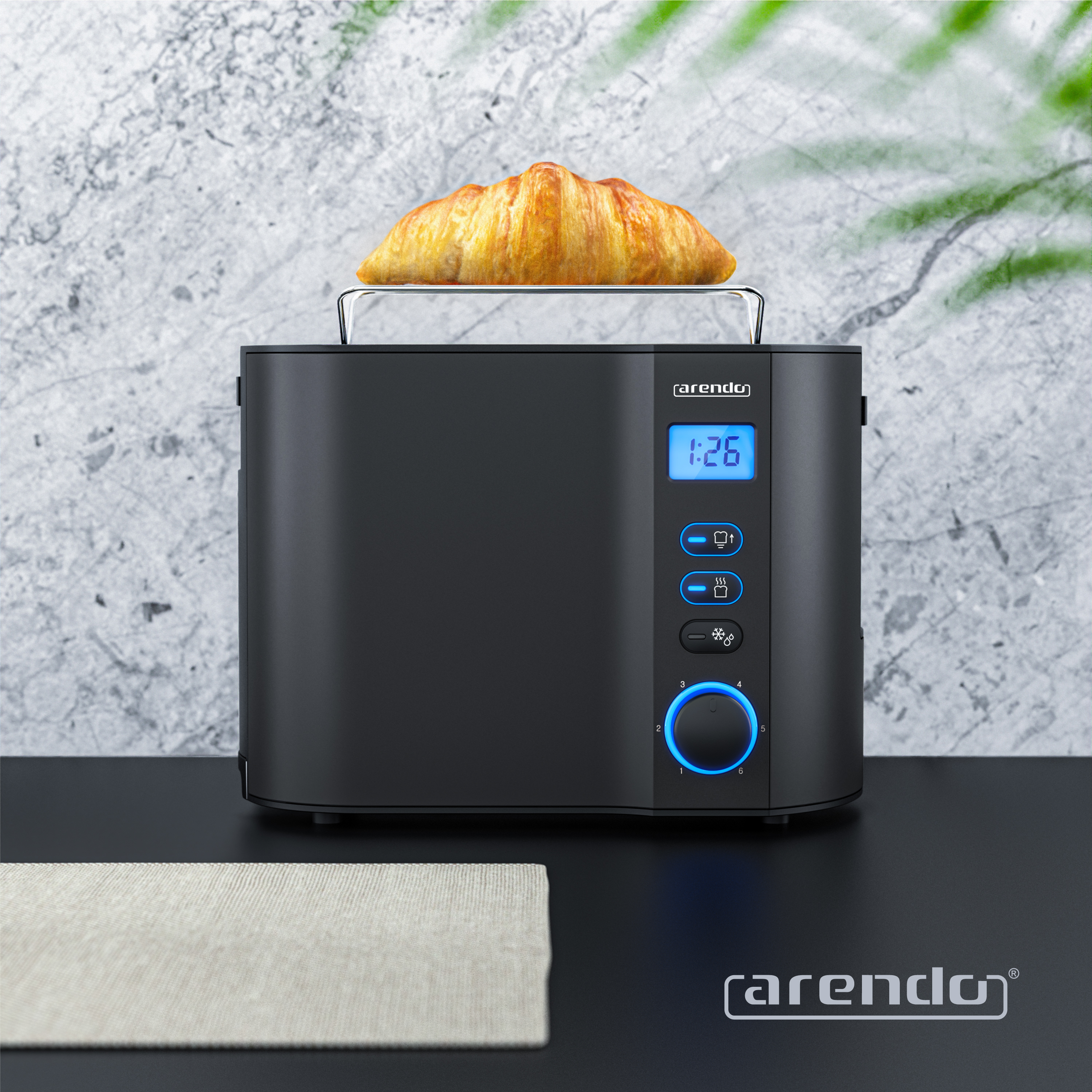 Ein schwarzer Toaster mit einem Croissant. Er hat ein Digitaldisplay und Knöpfe. Eine beige Tischmatte ist im Vordergrund.