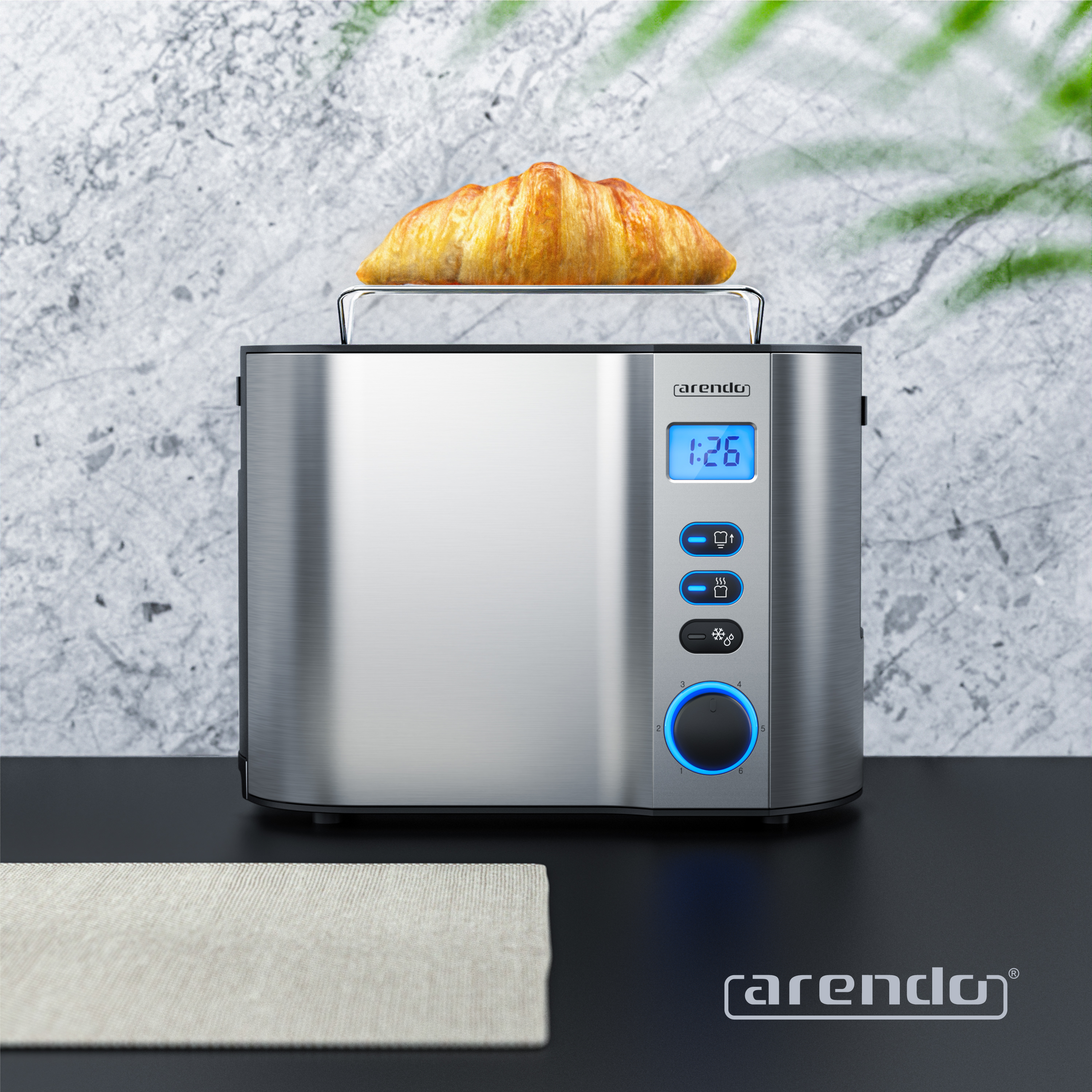 Ein Toaster aus Edelstahl mit einem Croissant darauf. Er hat ein digitales Display und Knöpfe. Der Hintergrund ist eine Marmorwand.