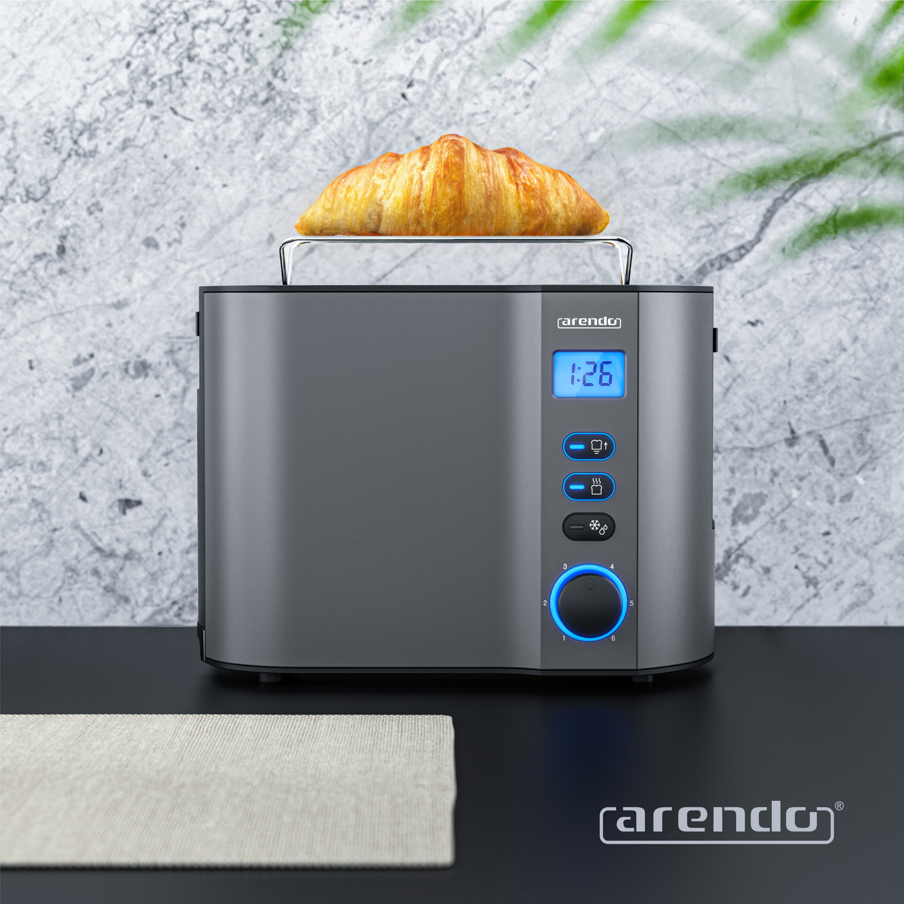 Ein Toaster mit einem Croissant. Er hat ein digitales Display und Knöpfe. Vorne liegt eine beige Tischdecke.