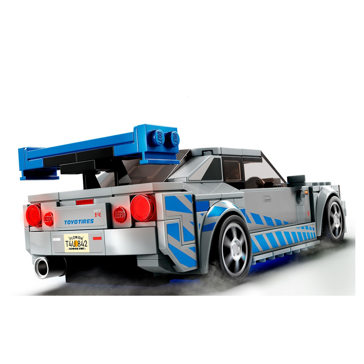 Un coche Lego gris con detalles azules. Tiene un alerón, luces traseras rojas y una placa de Florida. Las ruedas giran.