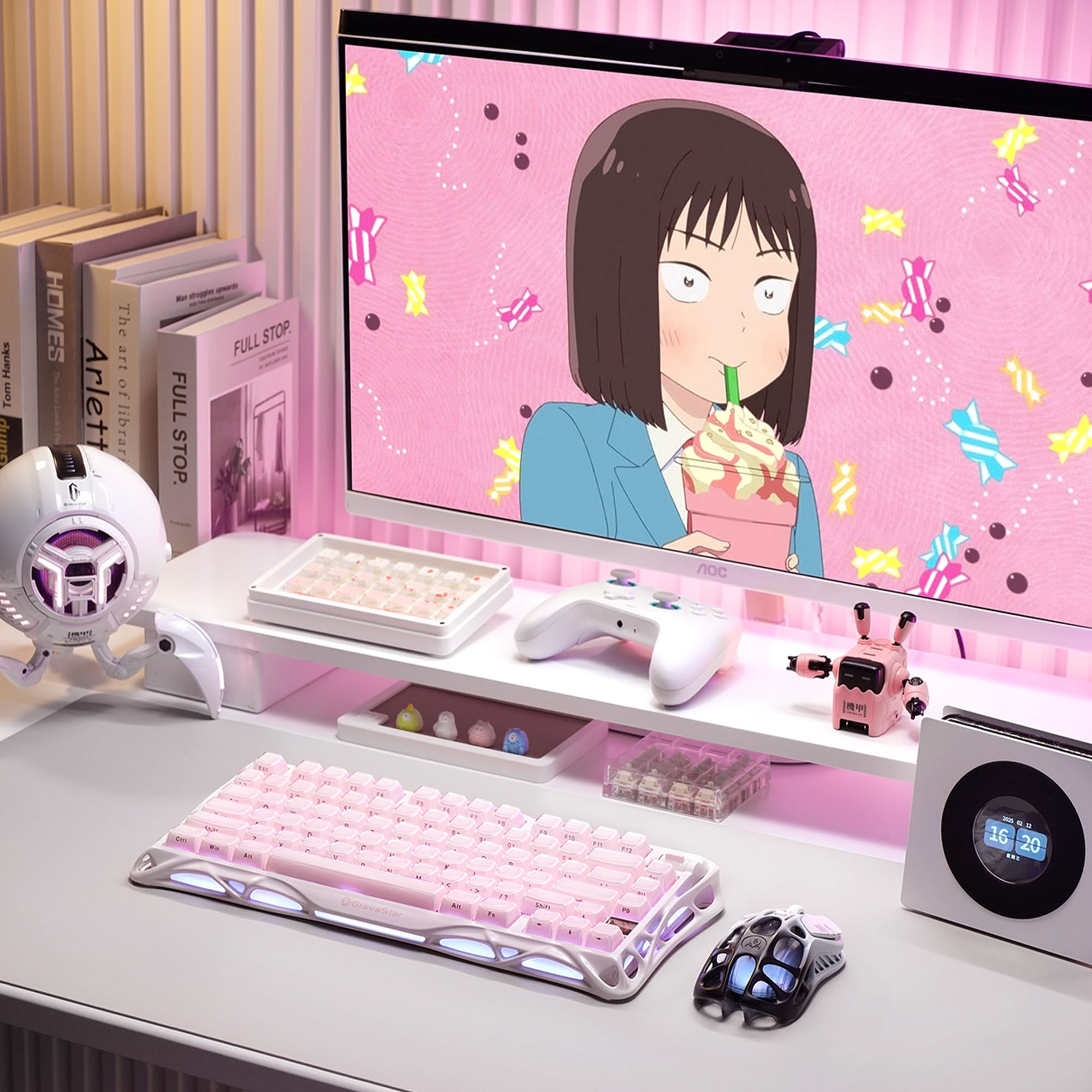 Anime gösteren bir monitörle pembe temalı bir masaüstü kurulumu. Bir klavye, fare, hoparlör ve diğer aksesuarlar var.