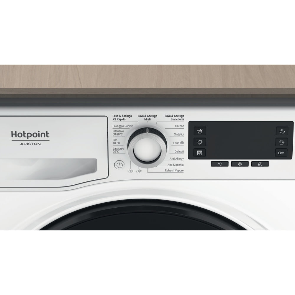 Una lavatrice Hotpoint bianca, con un pannello di controllo con un quadrante e vari pulsanti per i cicli di lavaggio e le impostazioni.