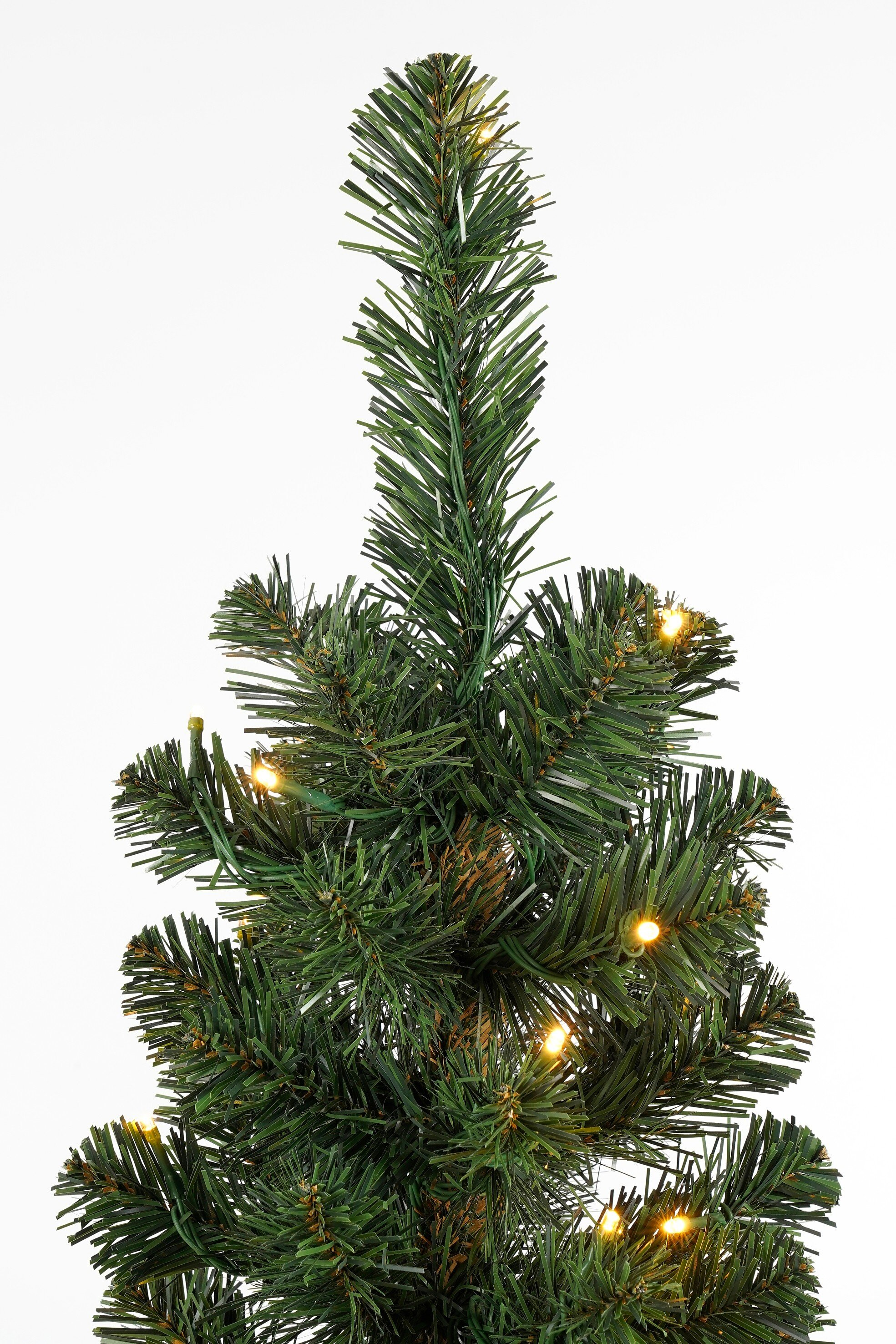 Gros plan sur un sapin de Noël vert avec de petites lumières jaunes, sur fond blanc.