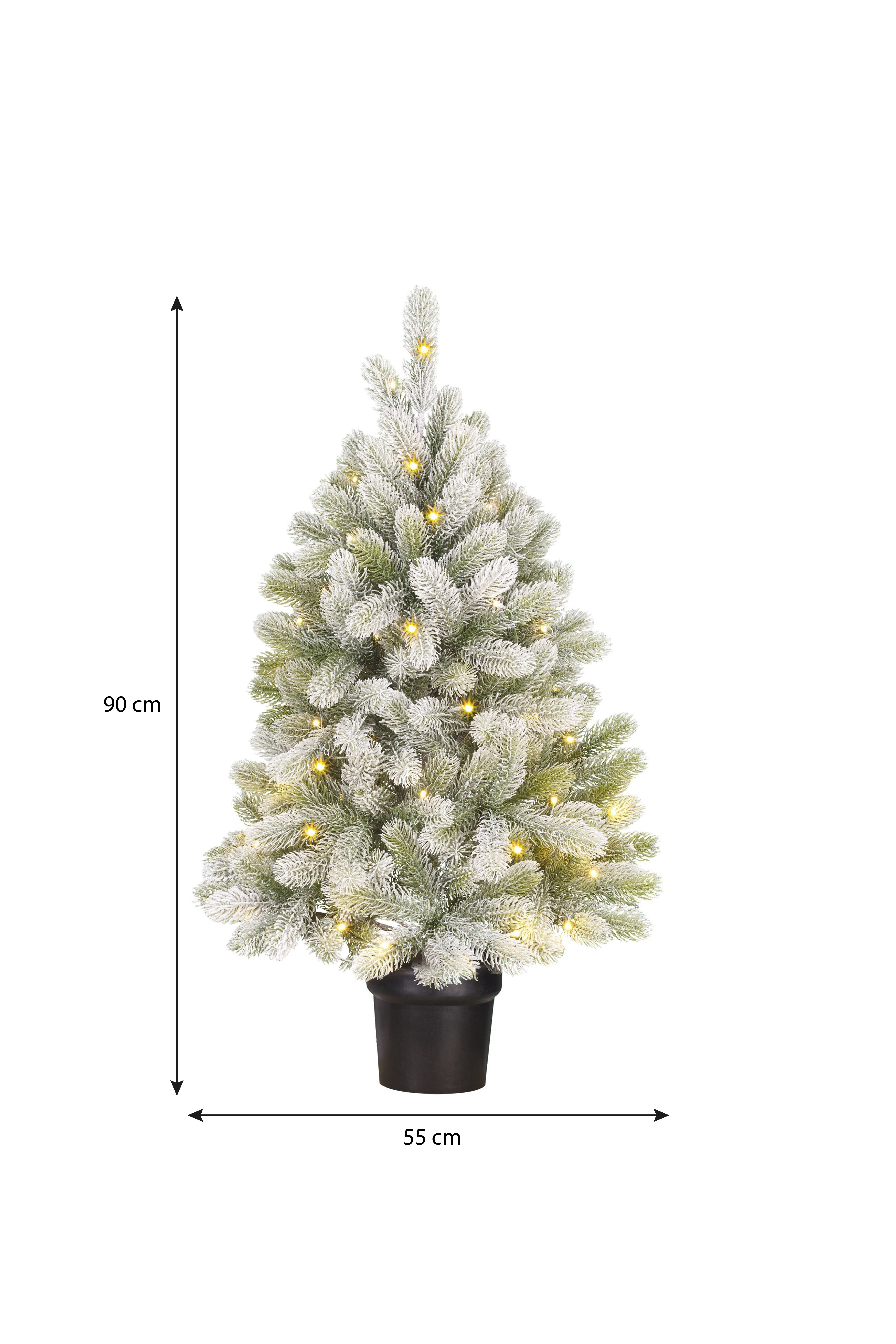 Un petit sapin de Noël artificiel, 90 cm de haut, avec lumières et effet neige. Il est dans un pot noir de 55 cm de large.