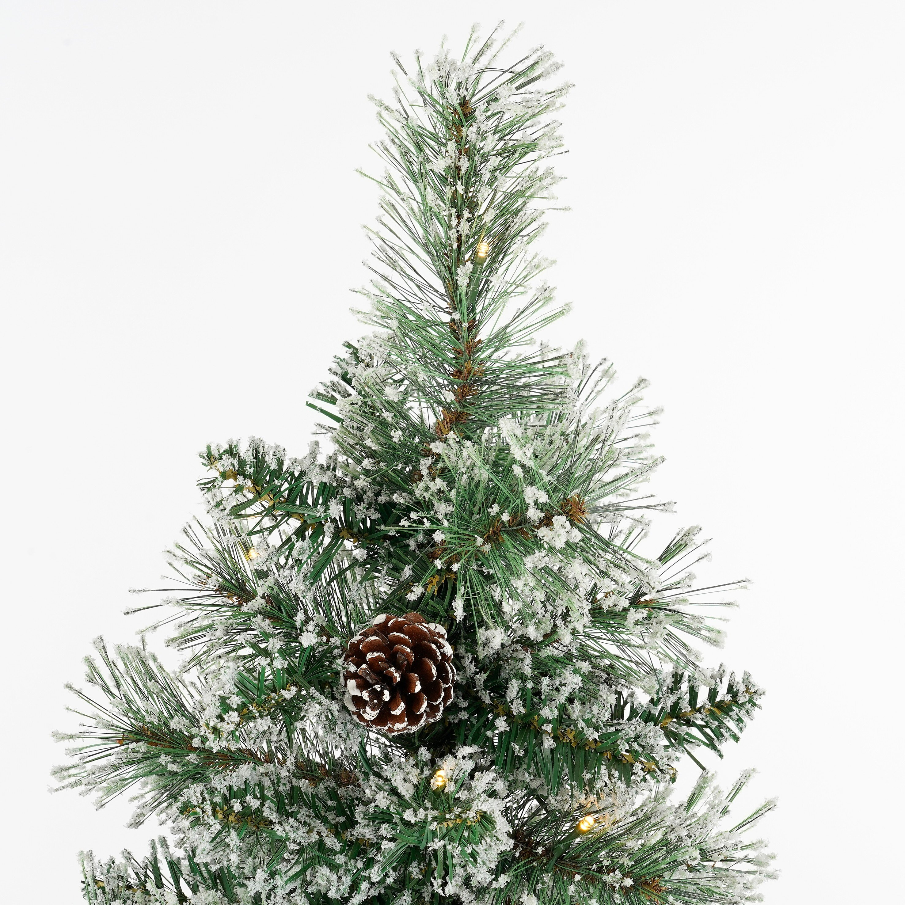 Close-up van een kleine kerstboom met sneeuwachtige frosting en een dennenappel, tegen een witte achtergrond.