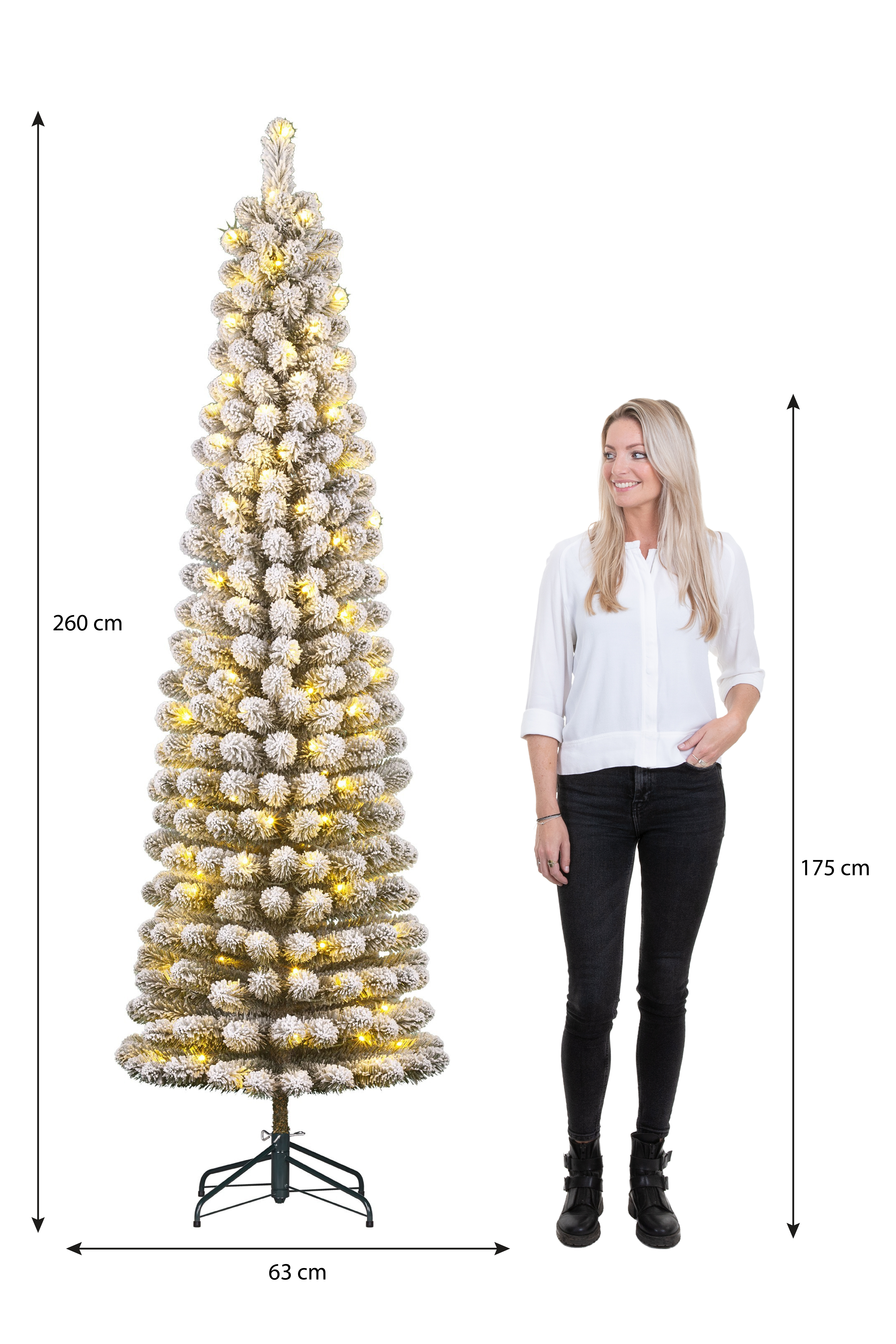 Une femme se tient à côté d'un grand sapin de Noël enneigé avec des lumières. Les dimensions sont indiquées.