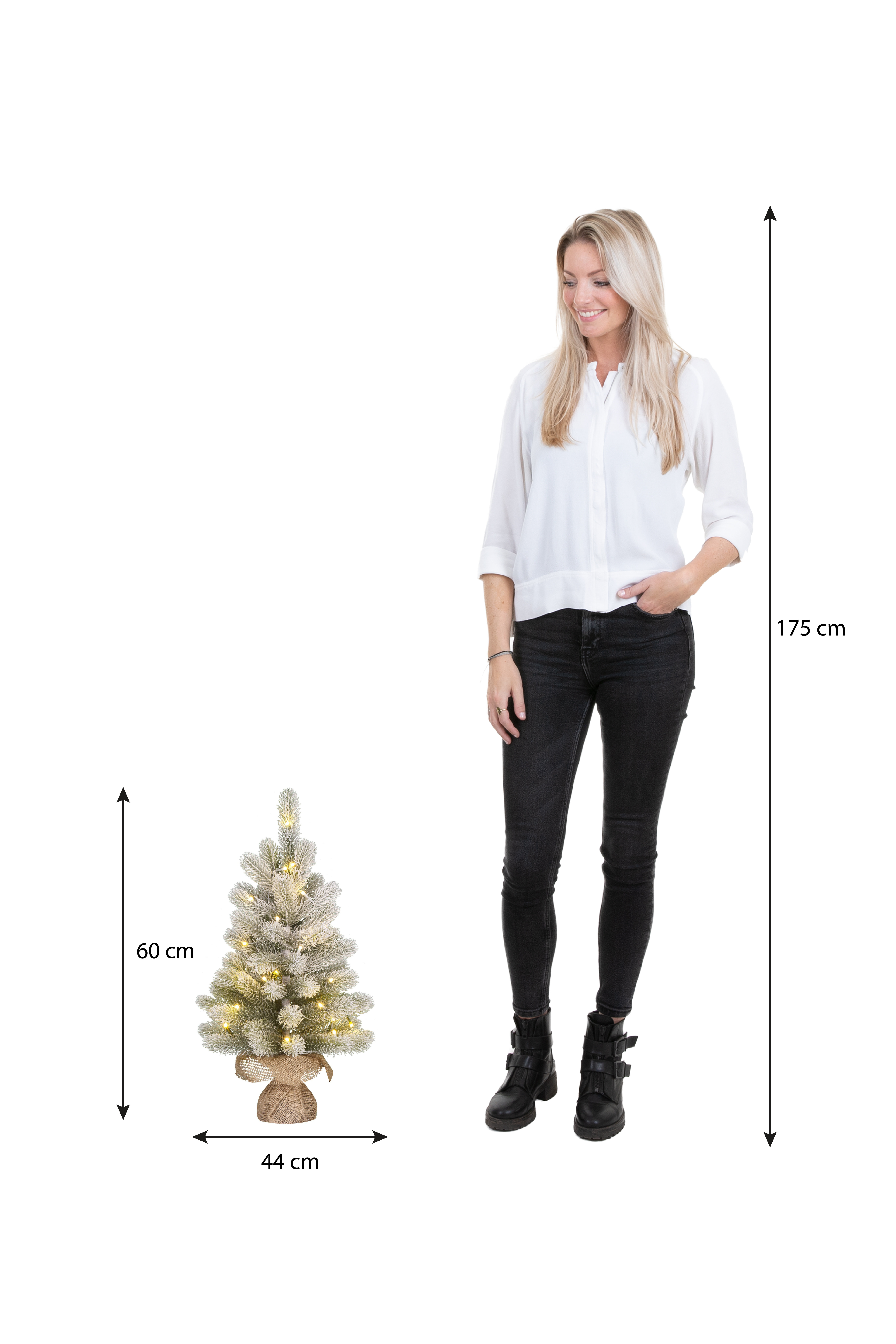 Une femme se tient près d'un petit sapin de Noël. L'arbre est décoré de lumières. Les dimensions sont indiquées.