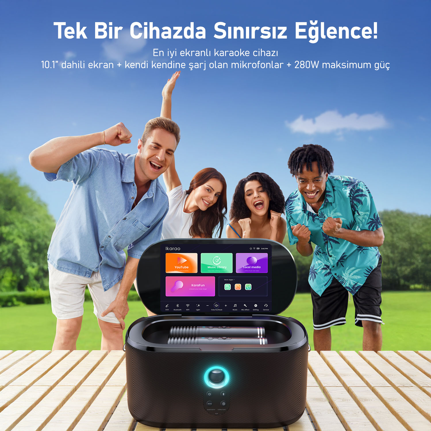 Dört kişilik bir grup karaoke makinesinin tadını çıkarıyor. Makine, uygulamaları gösteren bir ekrana sahip. Arka planda yeşil bir alan ve mavi gökyüzü.