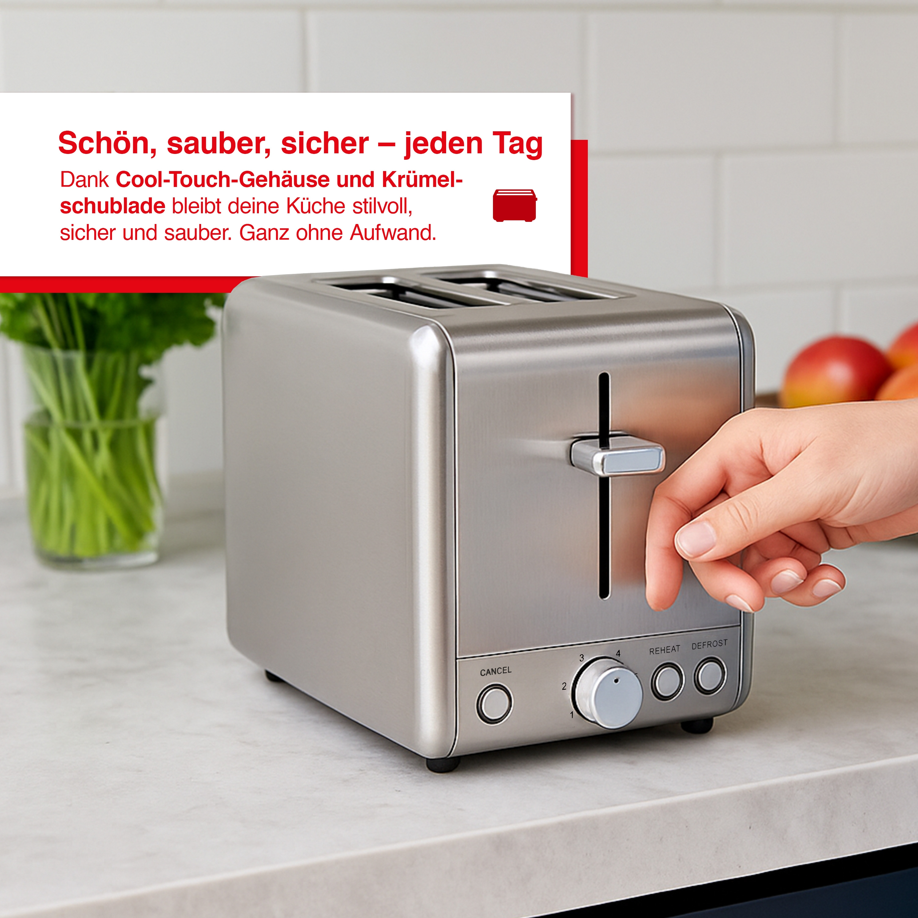 Srebrny toster z ręką dotykającą dźwigni. Szklany wazon z zielonymi roślinami po lewej stronie.