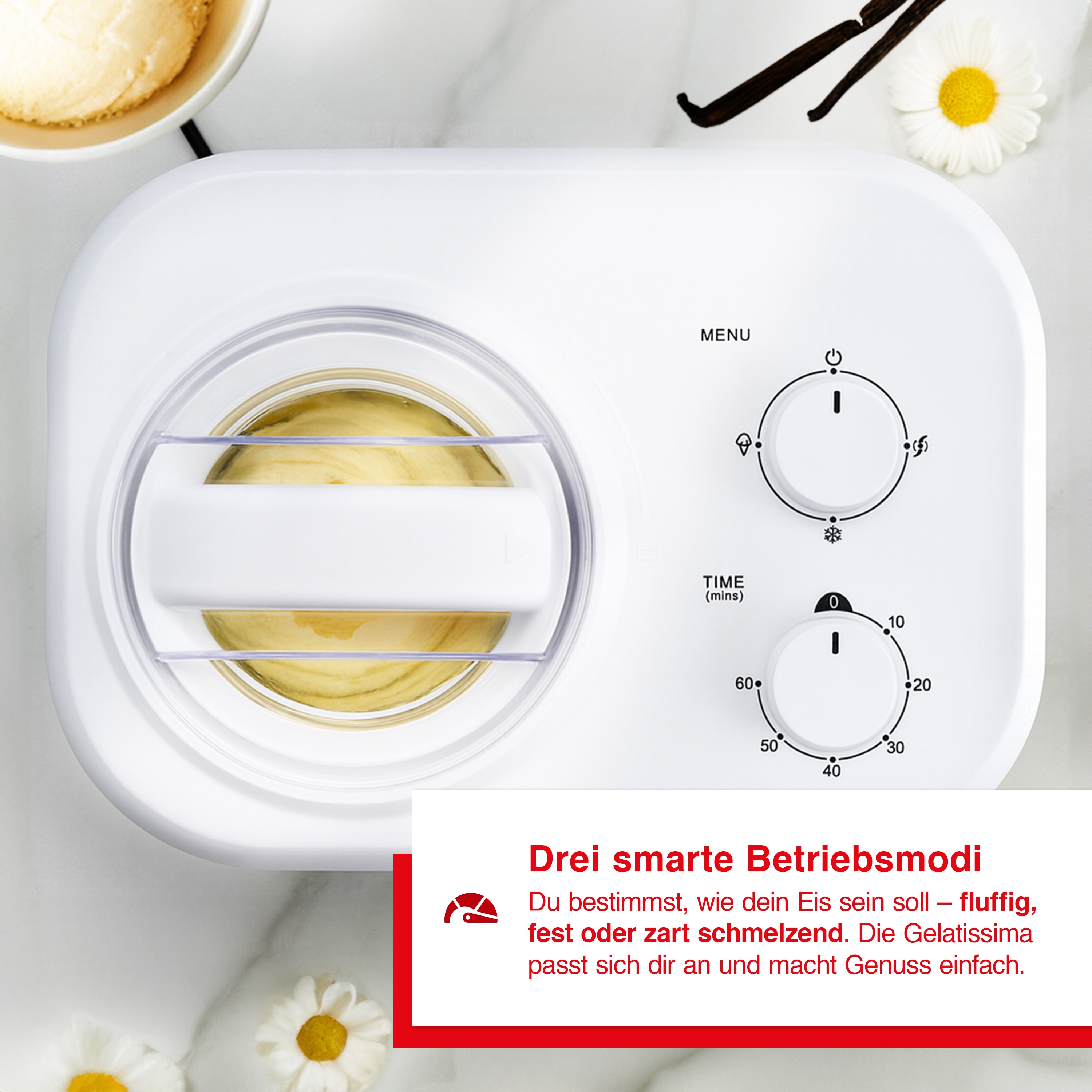 Eine weiße Eismaschine mit Knöpfen und einem transparenten Deckel. Vanilleschoten und Blumen sind im Bild.