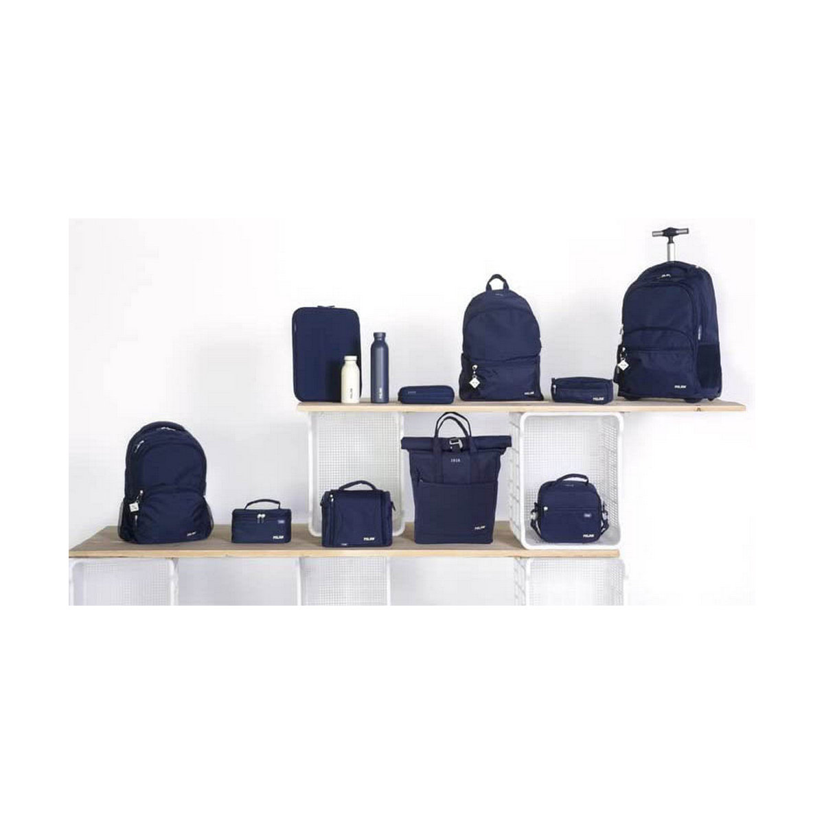 Verschiedene marineblaue Taschen und Accessoires werden auf Regalen vor weißem Hintergrund ausgestellt. Zu den Artikeln gehören Rucksäcke, Tragetaschen und Etuis.