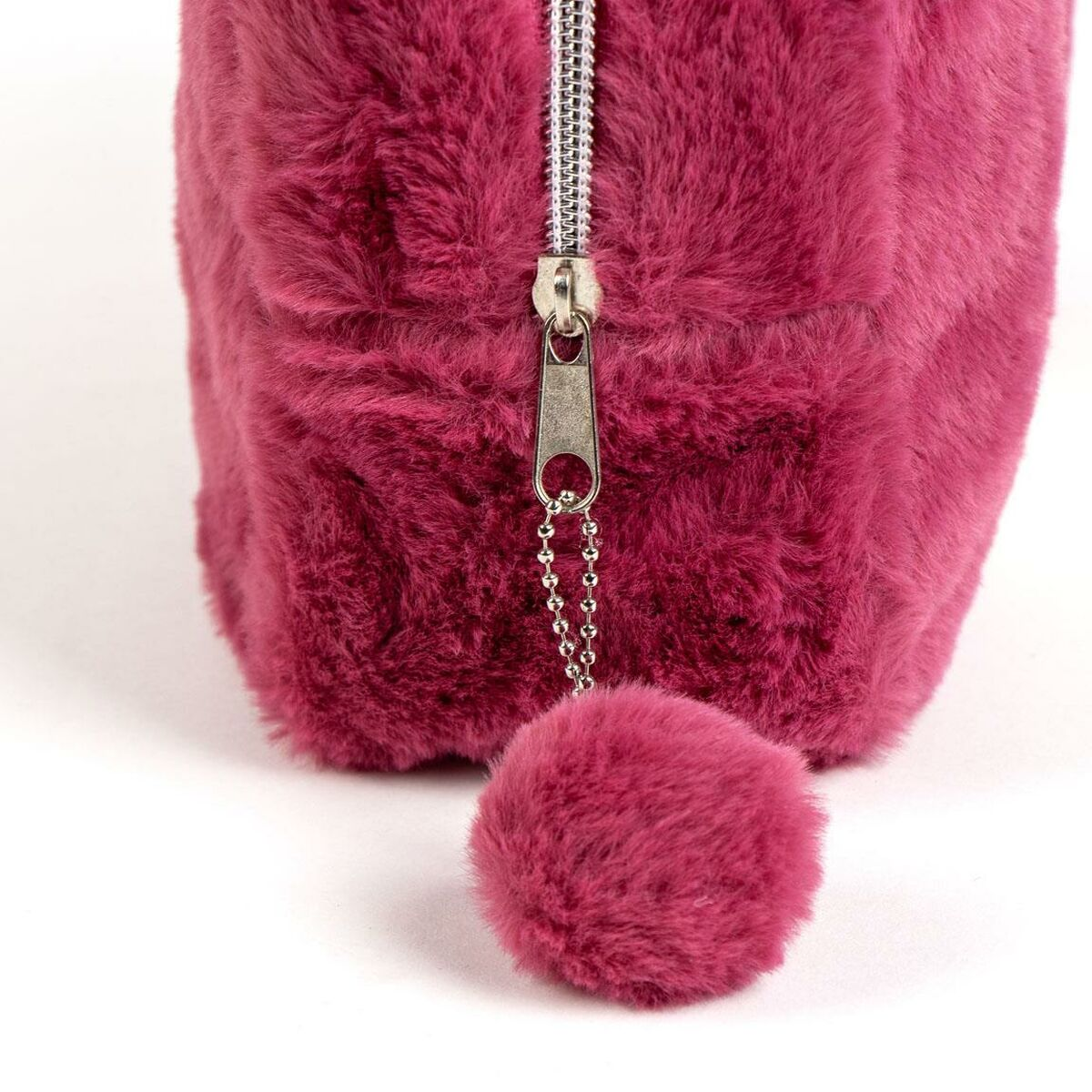 Eine flauschige, magentafarbene Tasche mit silbernem Reißverschluss und passendem Bommel auf weißem Hintergrund.