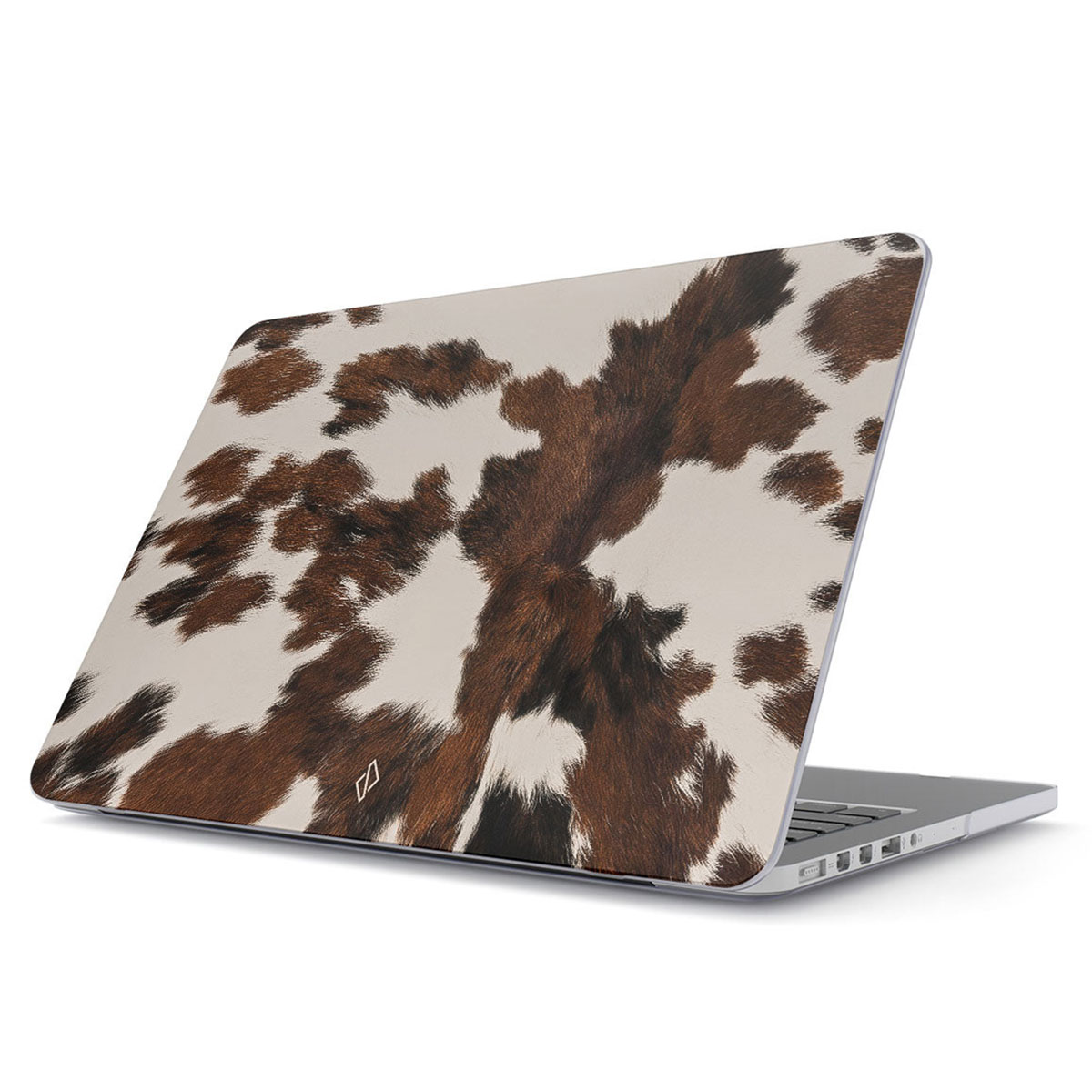 Laptop met een hoesje met koeienprint. De hoes heeft bruine en witte vlekken. De laptop staat schuin en toont het toetsenbord.