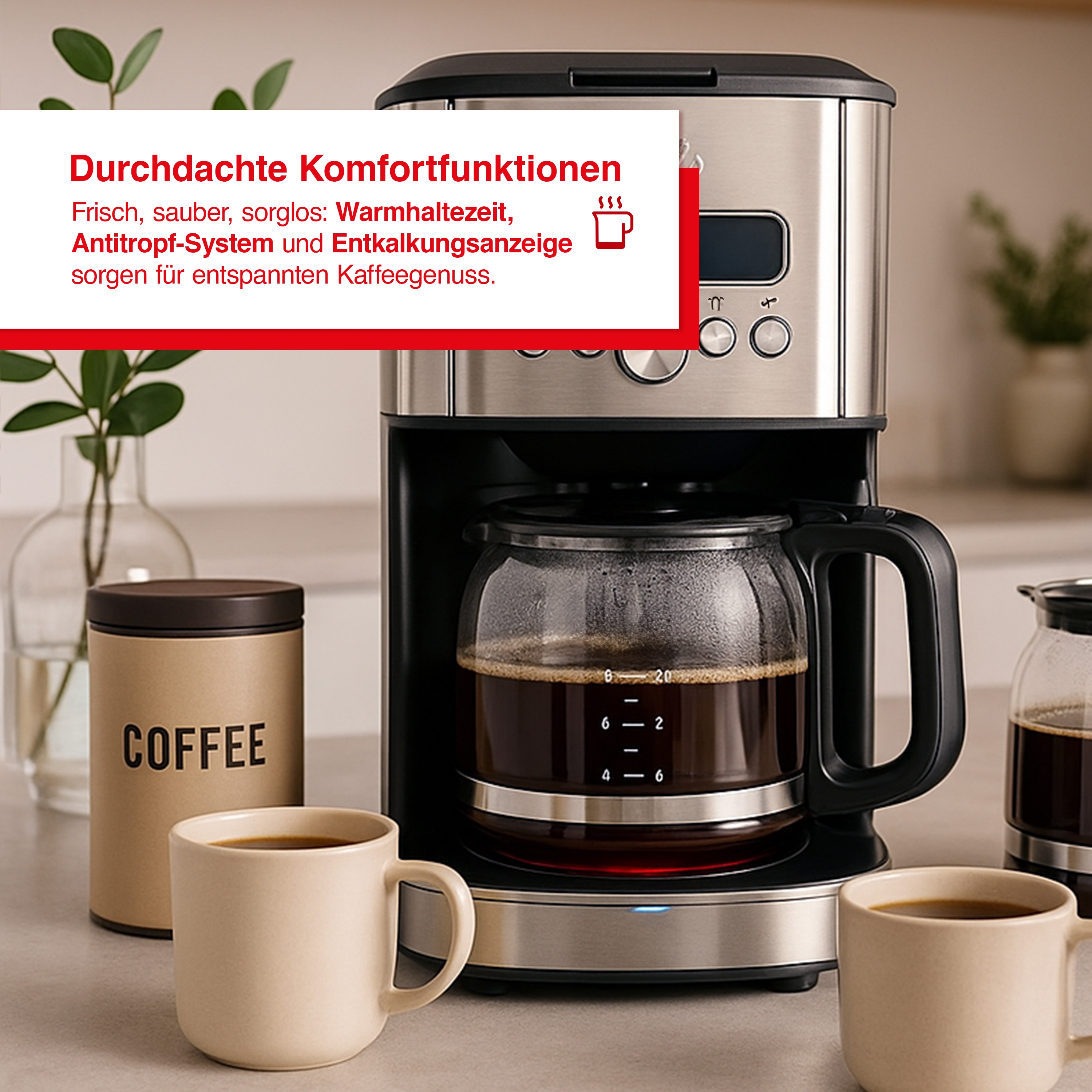 Eine Kaffeemaschine mit einer Glaskaraffe voller Kaffee. Ein Kaffeebehälter und zwei Tassen sind im Vordergrund.